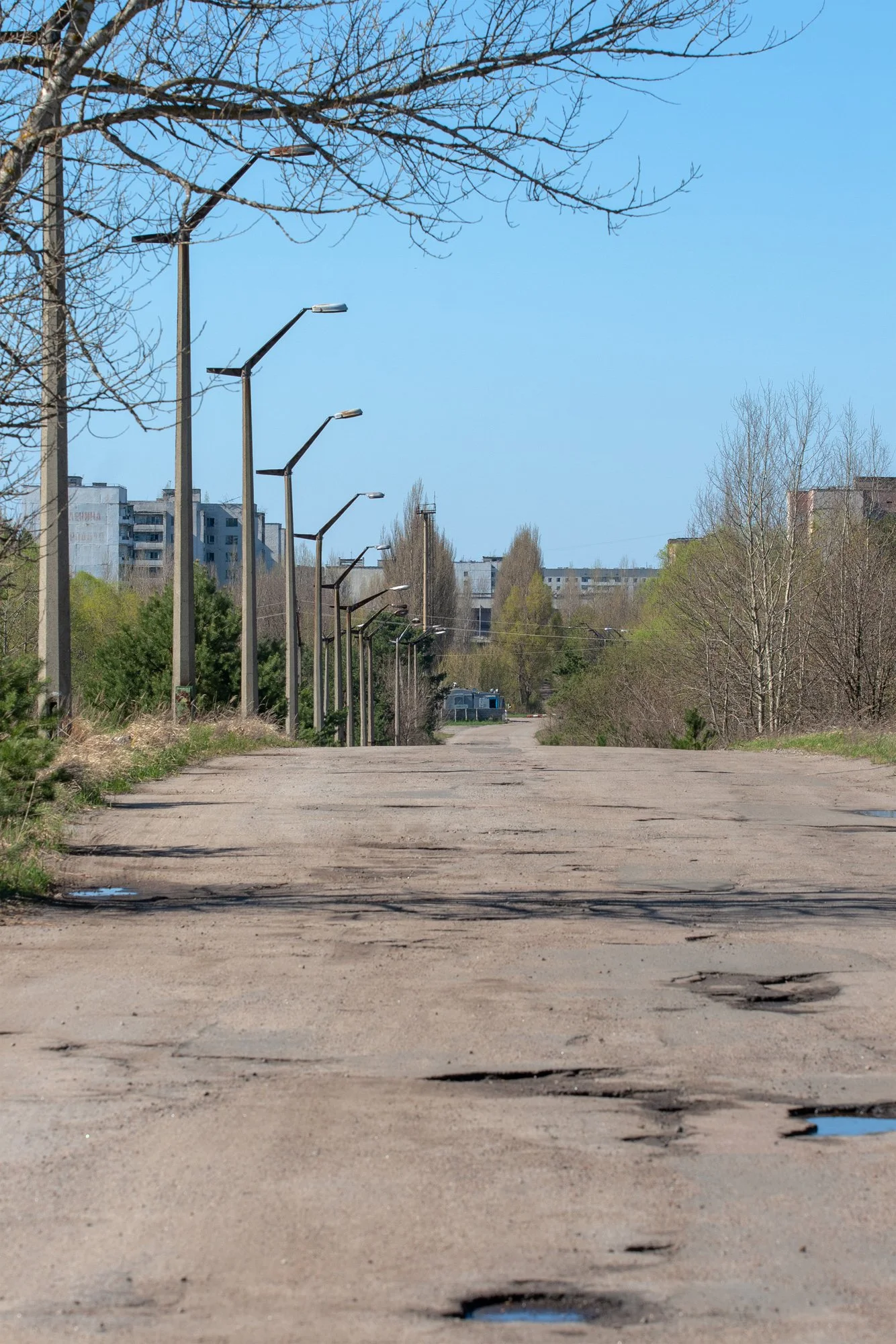 empty road leading into Pripyat with abandoned buildings in the distance Ukraine