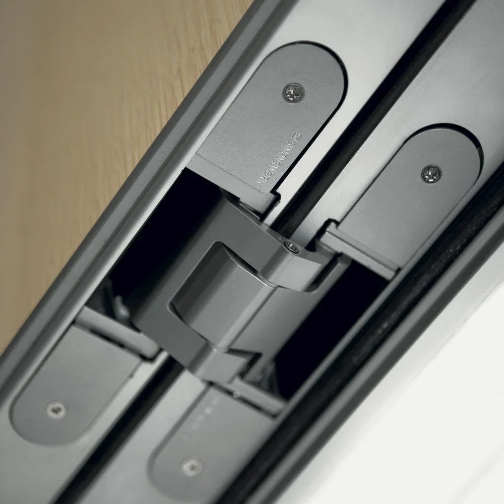 Particolare di una serratura elettronica su una porta, con componenti metallici e viti.