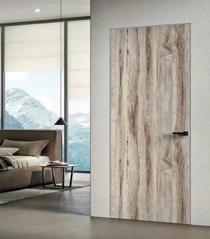 porta in legno chiaro in una stanza moderna con pareti bianche e finestra grande