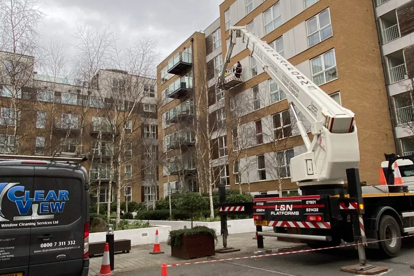 Clearview van and IPAF-operated cherry picker MEWP cleaning windows on a London apartment block