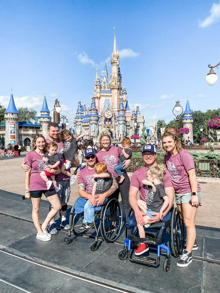  Achilles Freedom Team members  pose with their families in front of the Disney castle. 