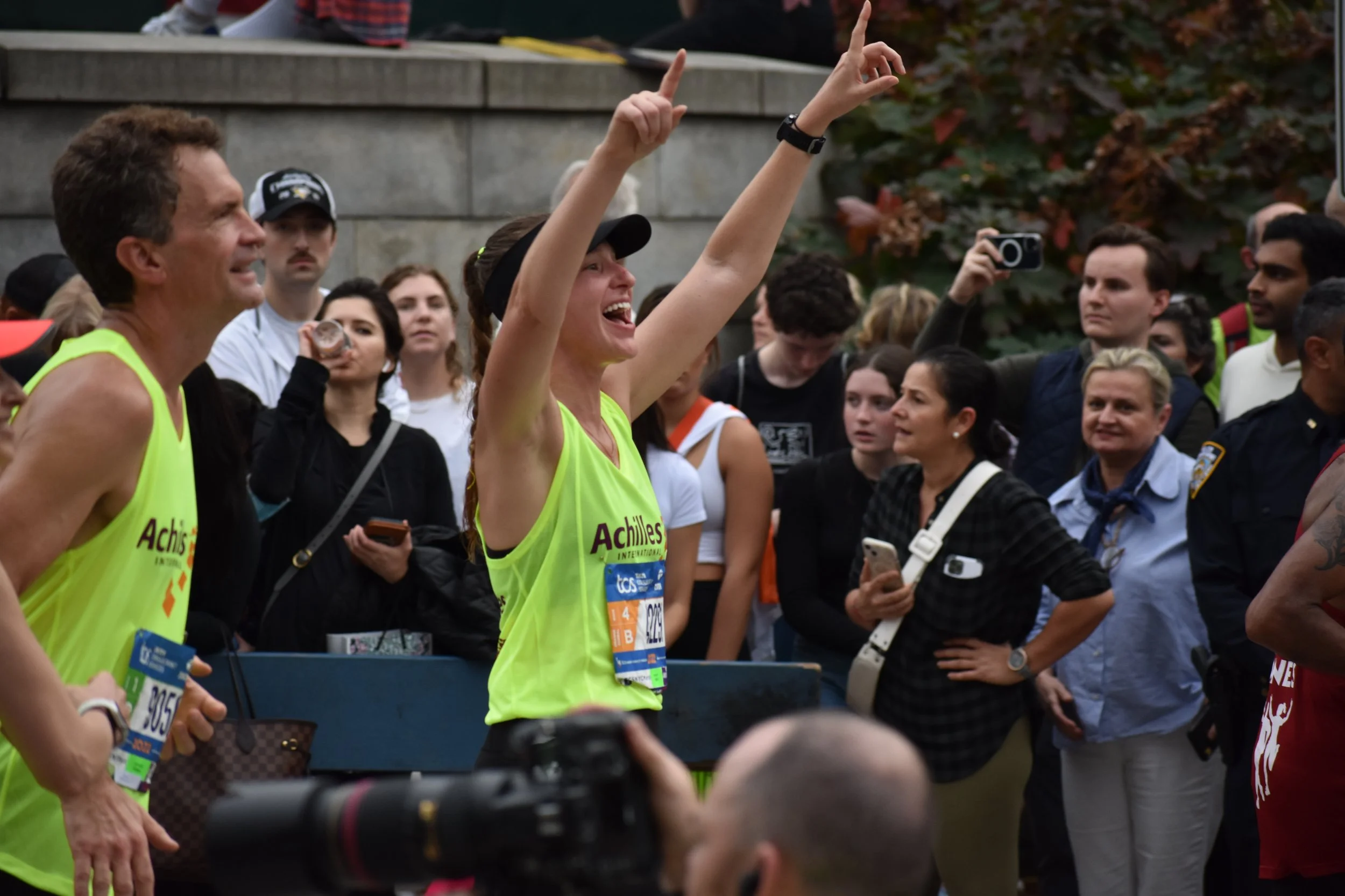  Achilles athlete and guide cheering while running past Engineer’s gate at the NYC Marathon 