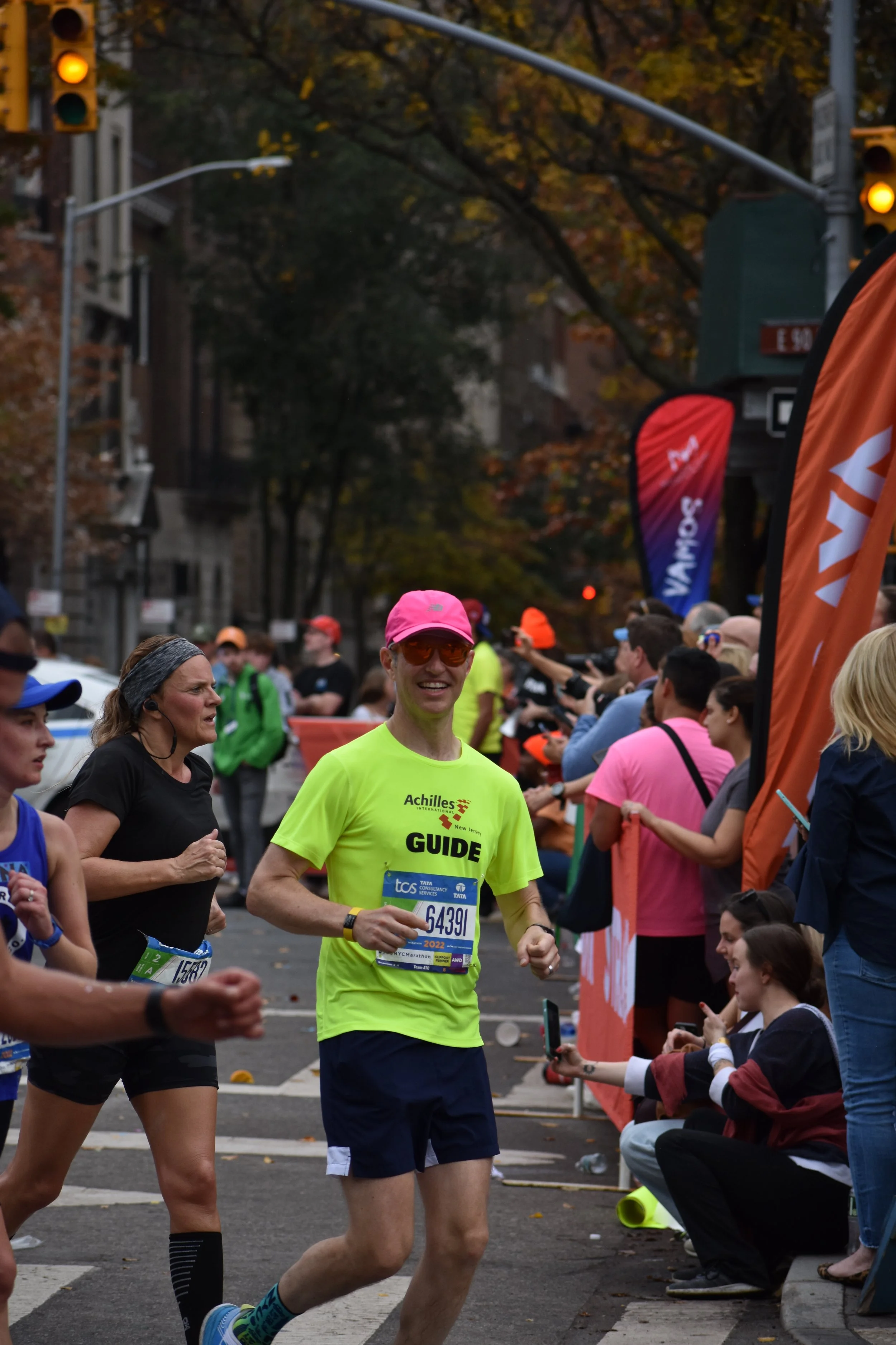  Achilles guide smiling as he passes Engineer’s Gate while running in the NYC Marathon 