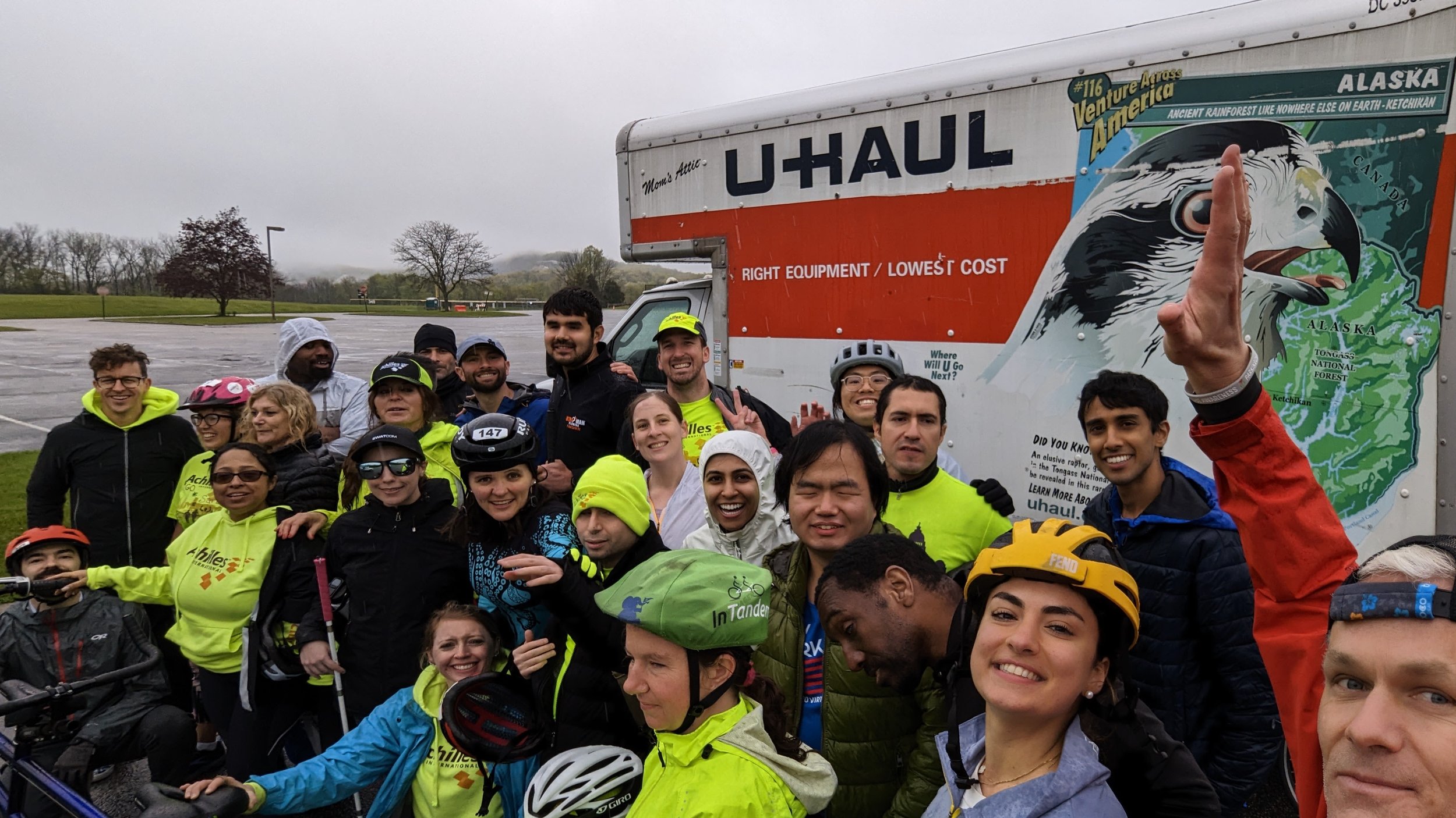  Group photo of Achilles members posing together in front of a U-Haul truck 