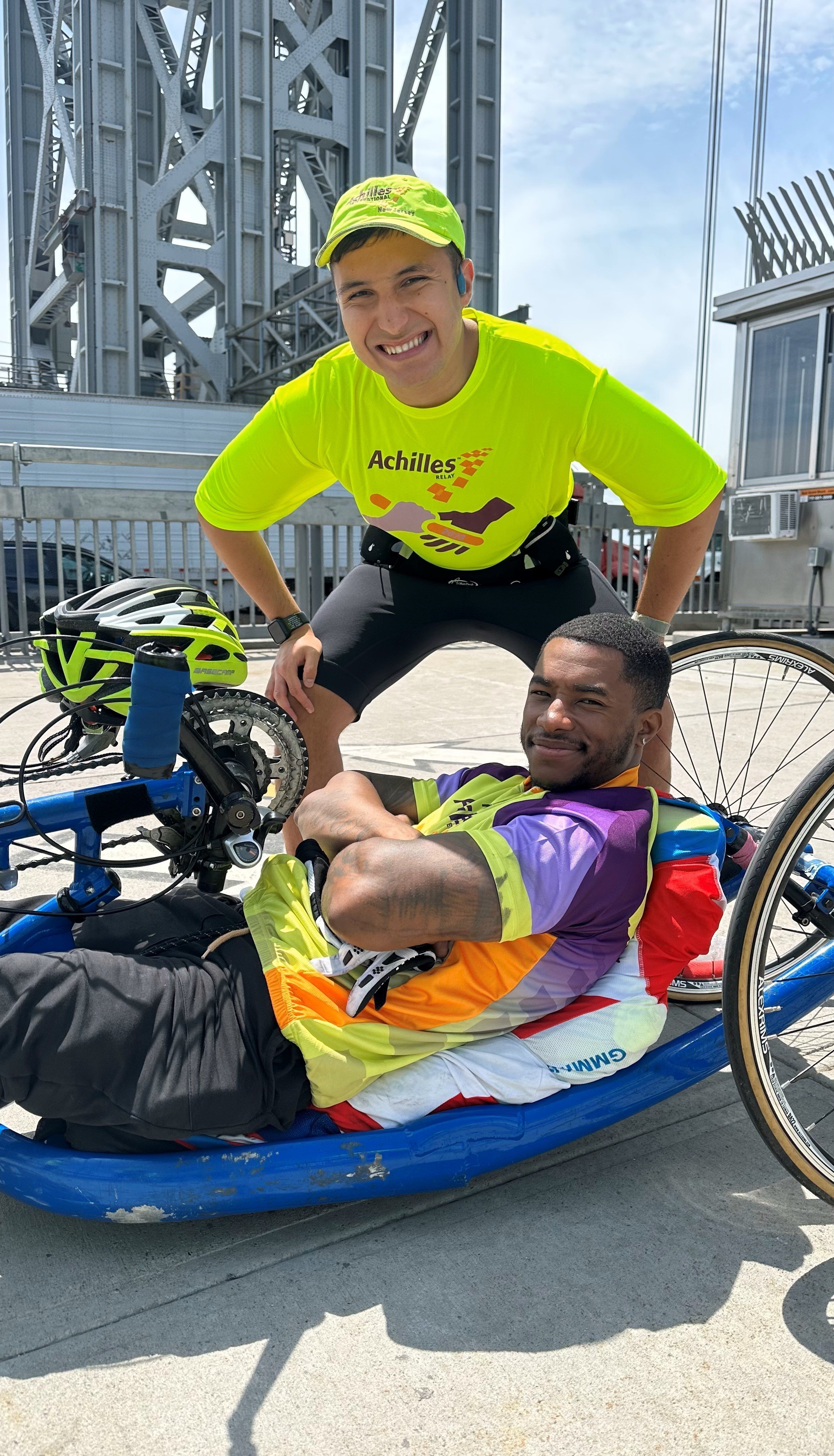  Achilles runner smiling with an athlete riding a handcycle 