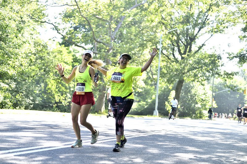  Achilles athlete and guide cheering and smiling together on the race course 