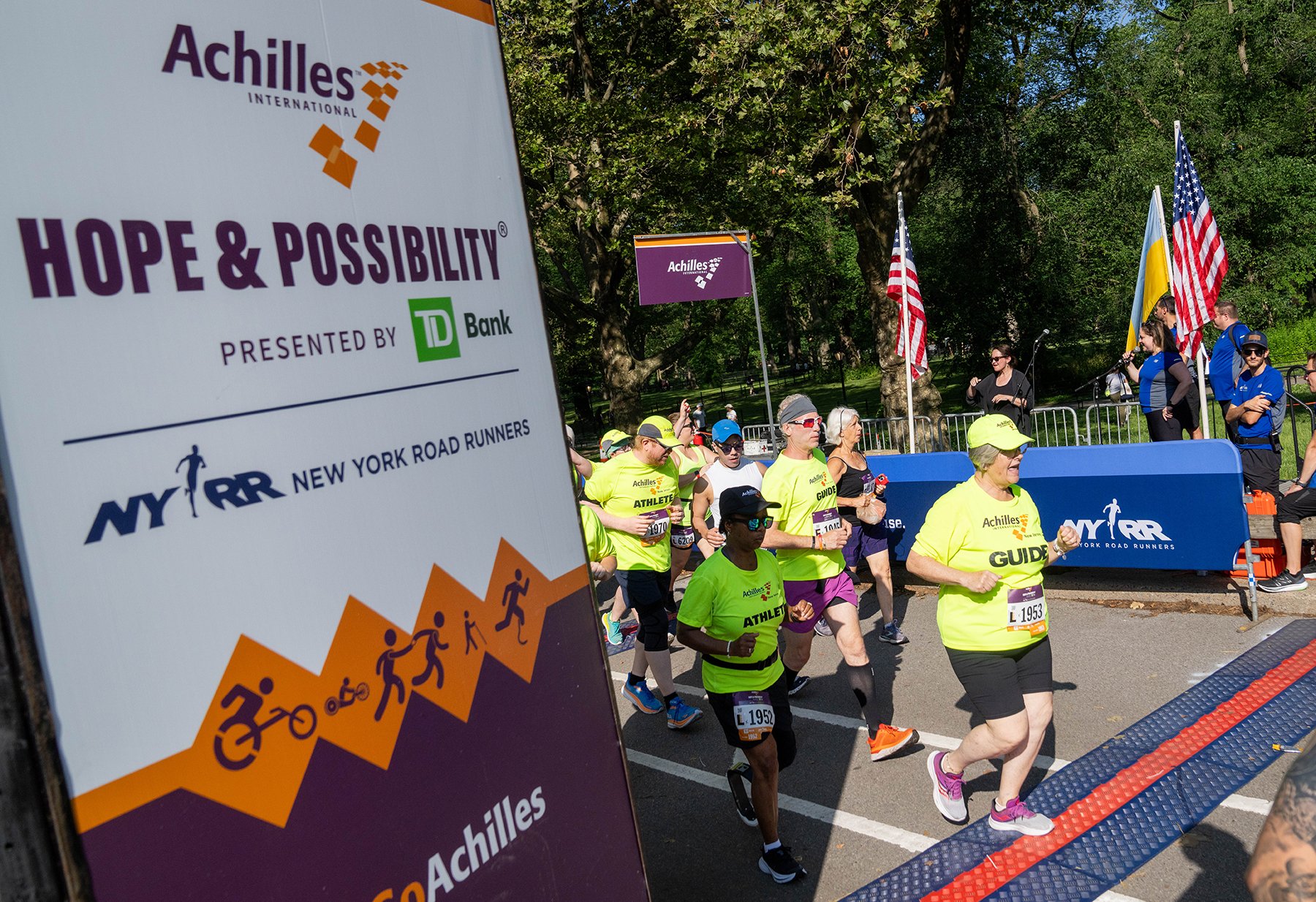  Photo of athletes crossing the start line of the Achilles Hope &amp; Possibility 4M 