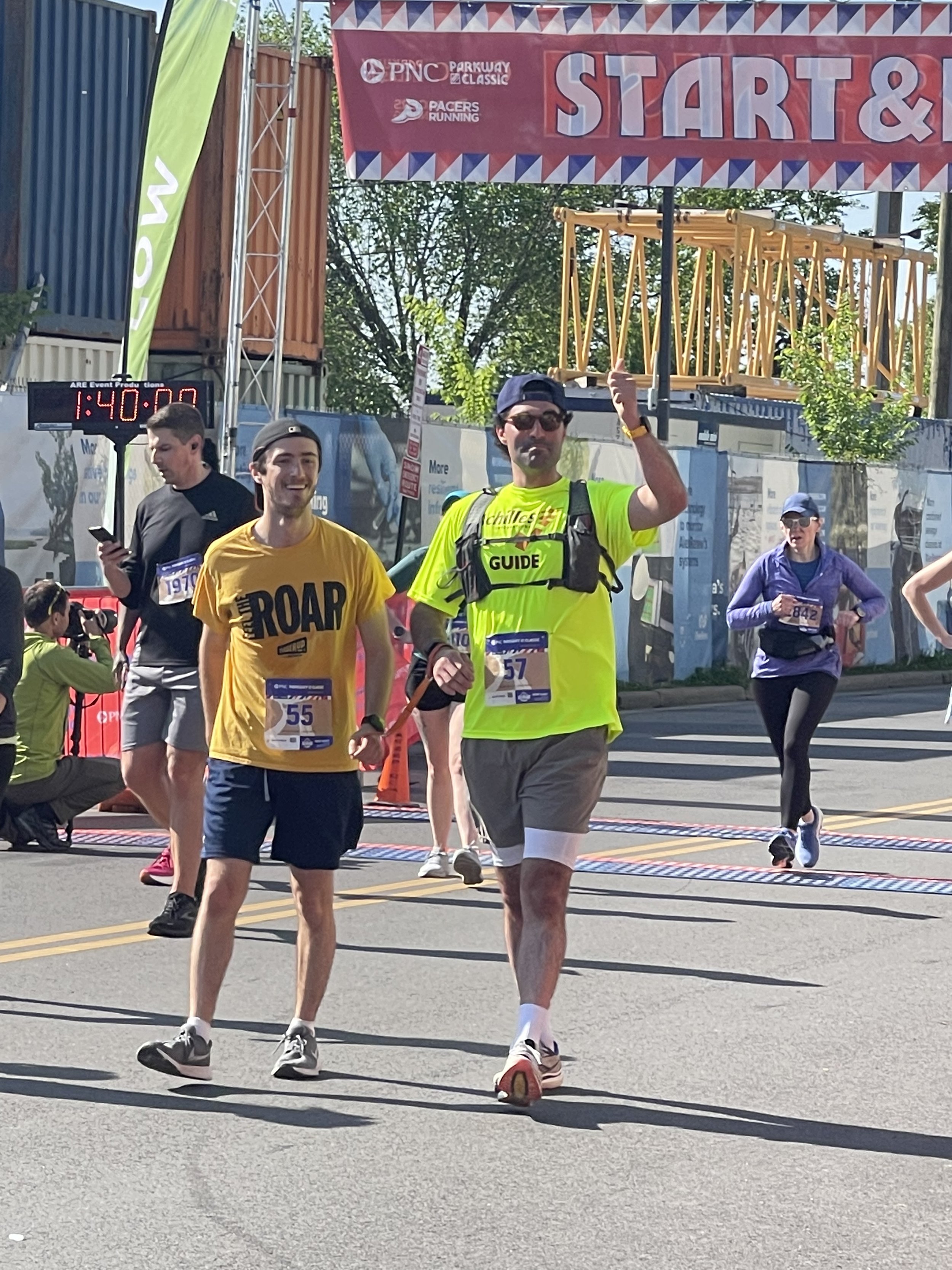  Tim and his guide smiling and running together on the race course  