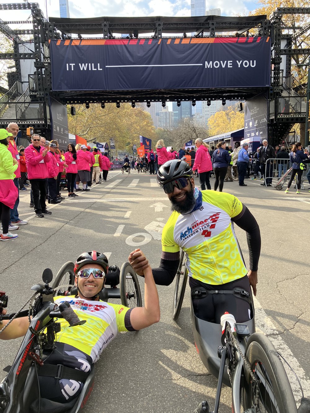 Achilles Freedom Team athletes holding hands and posing together at the NYC Marathon finish line 