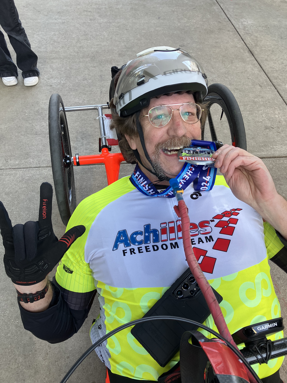 Achilles Freedom Team member posing and biting on his race medal  