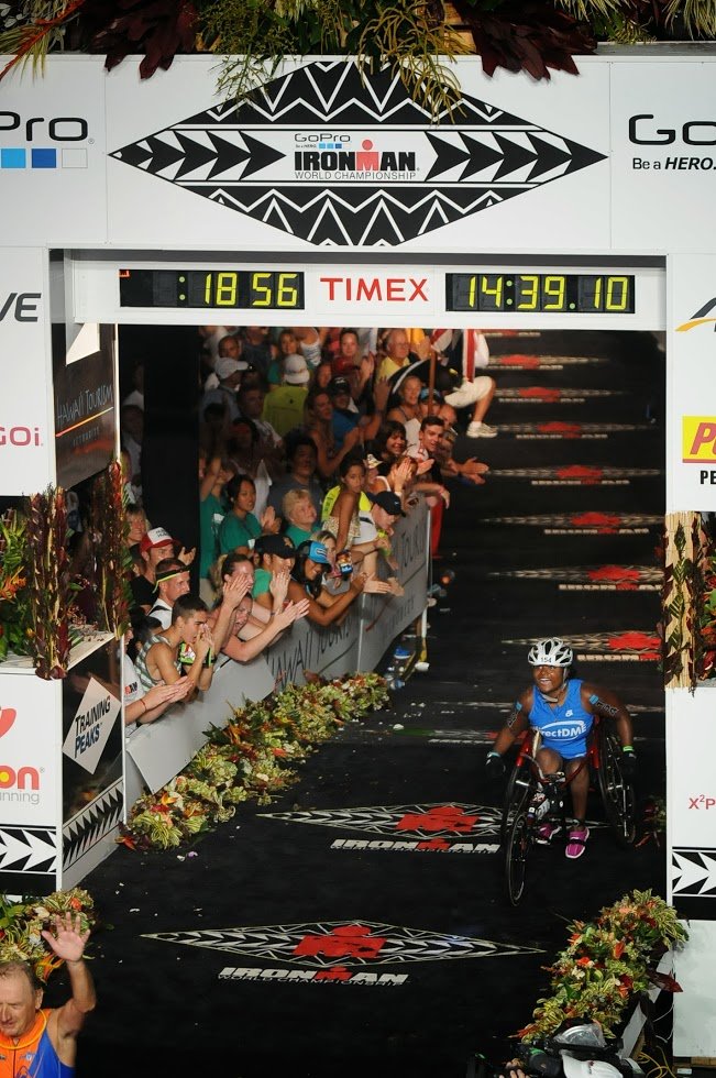  Minda cheering while crossing the finish line of Kona in her racing wheelchair 