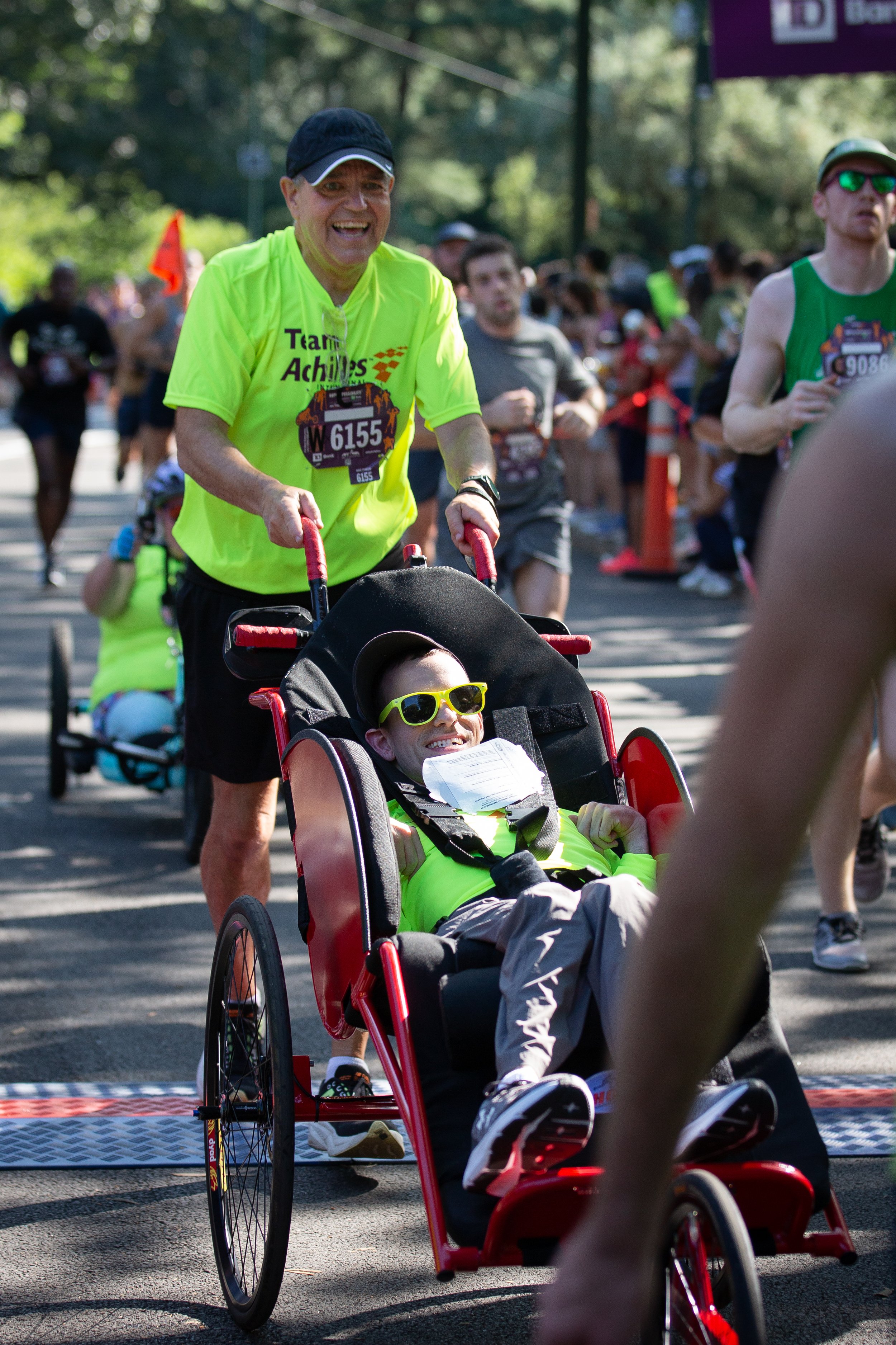 Andrew and John Burbank cheering as they cross the finish line together.