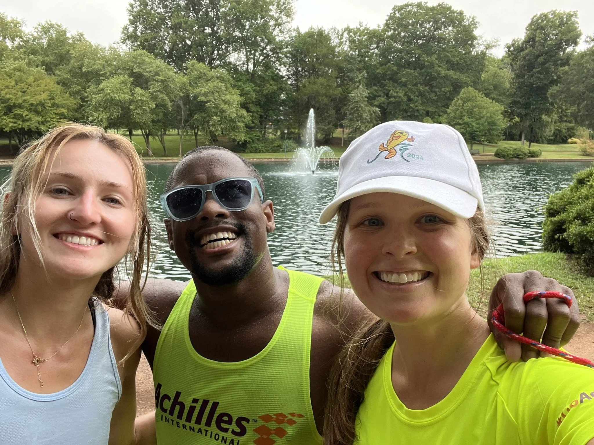  DJ smiling with his two guides in front of a fountain 