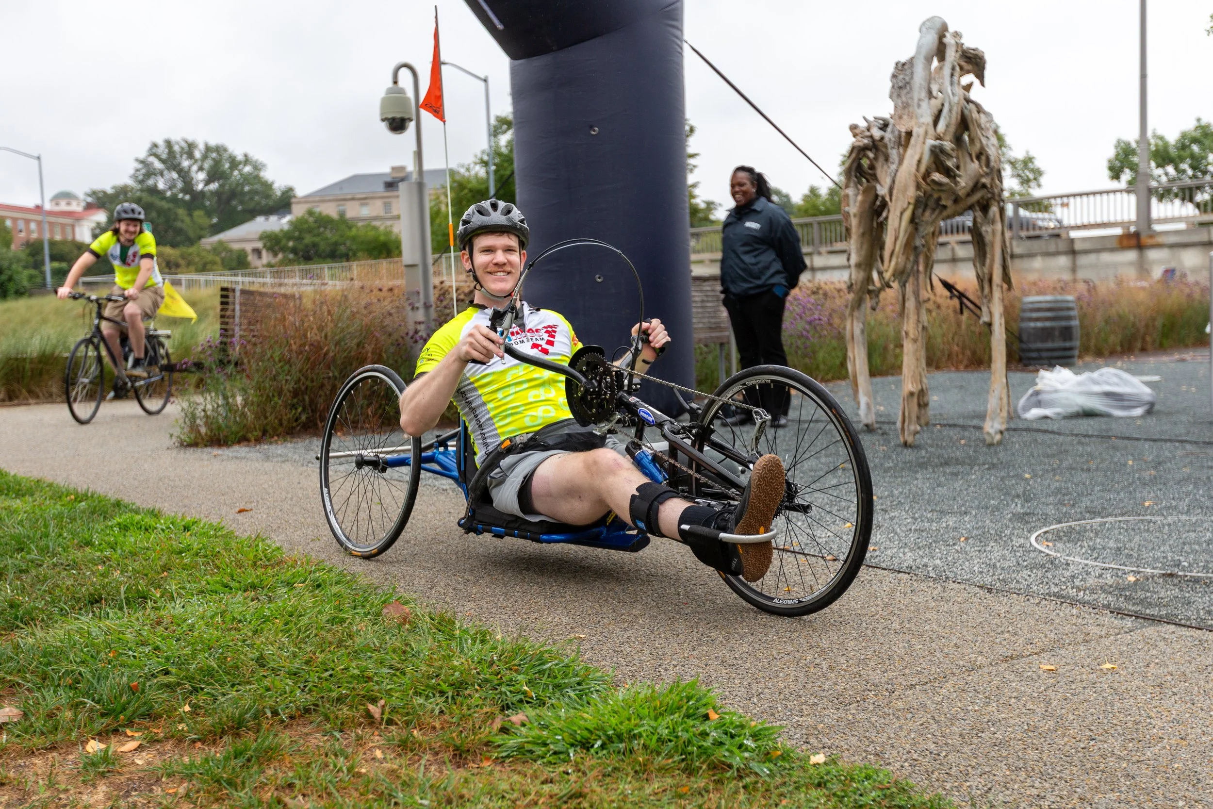 Achilles Freedom Team member smiling as he crosses the finish line on his handcycle