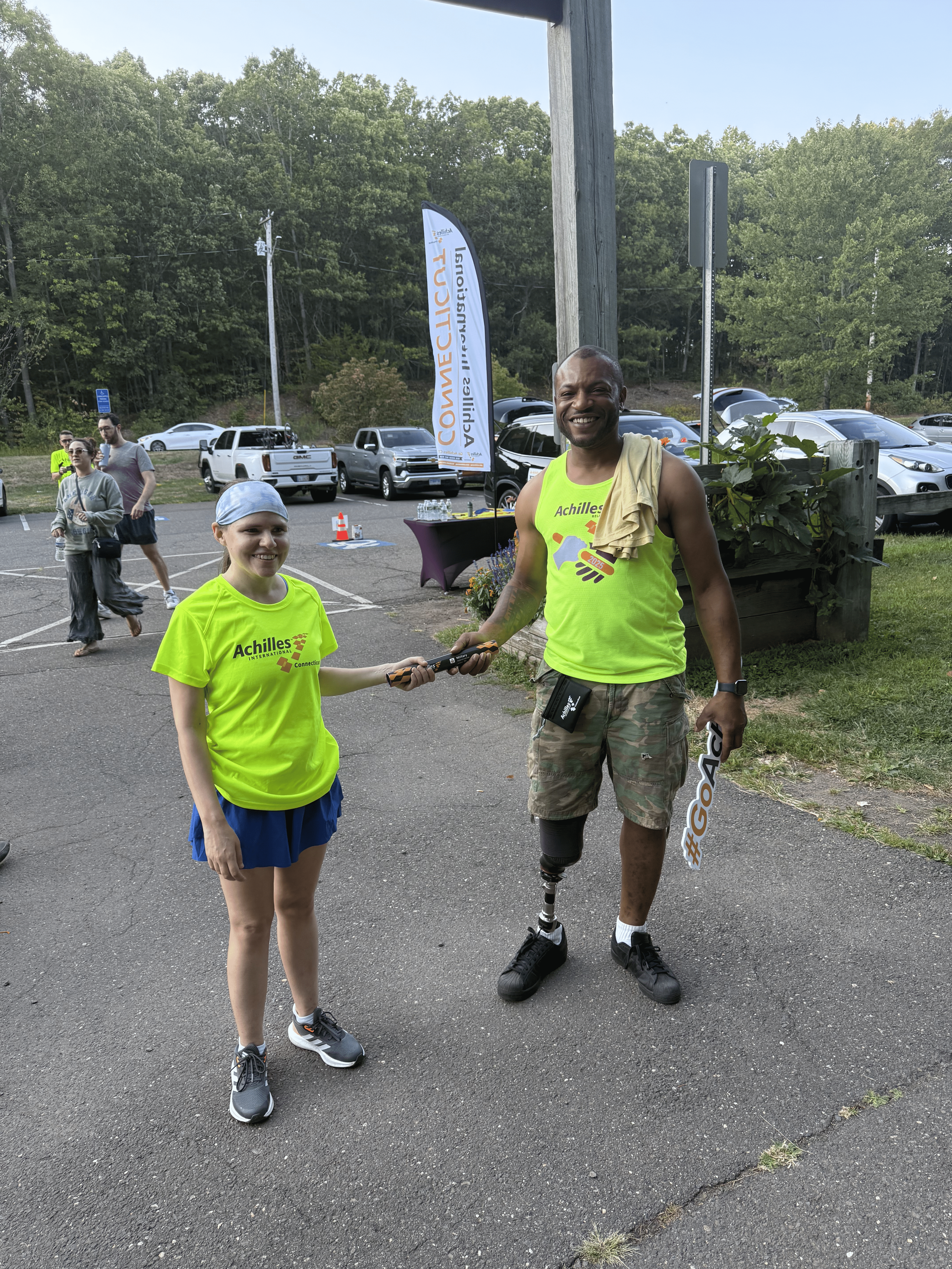 The Relay baton being passed to a member of Achilles Connecticut