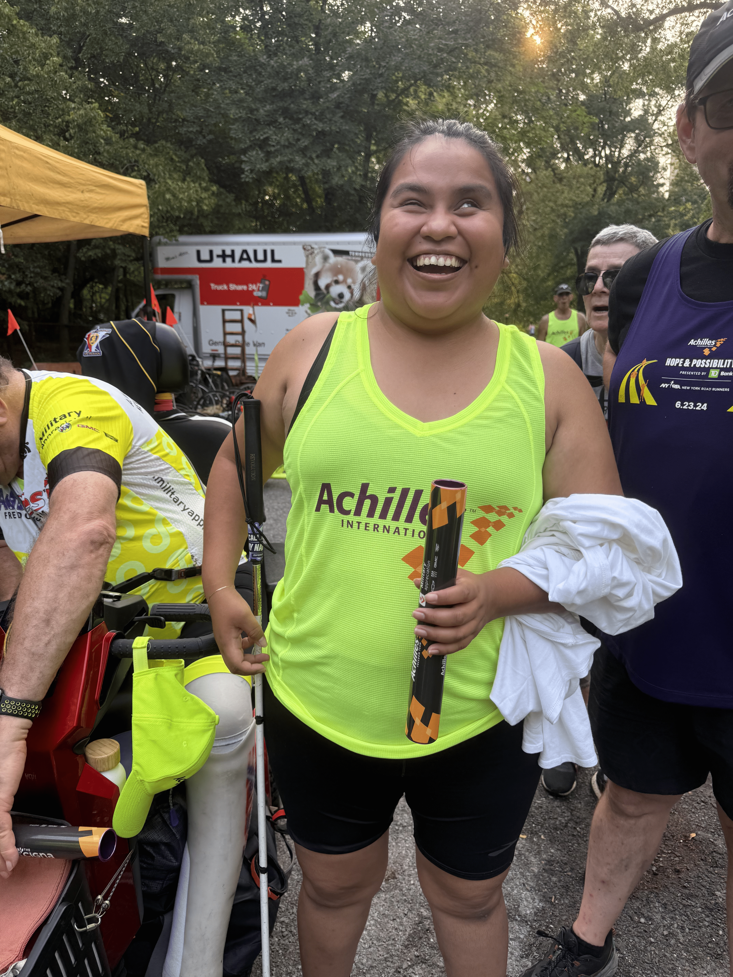 Achilles NYC member smiling with the baton.