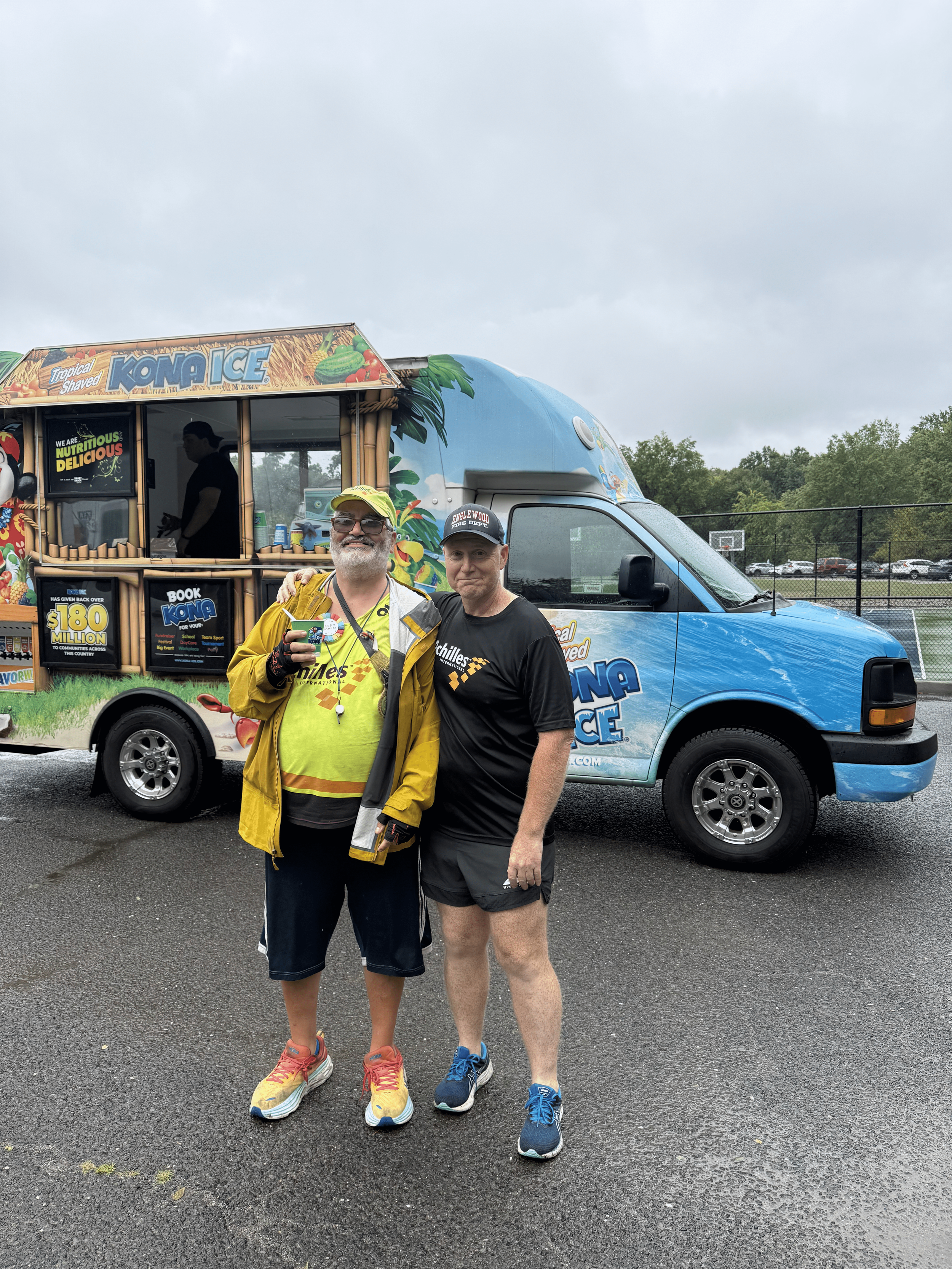Achilles New Jersey chapter lead posing with an athlete in front of an ice cream truck
