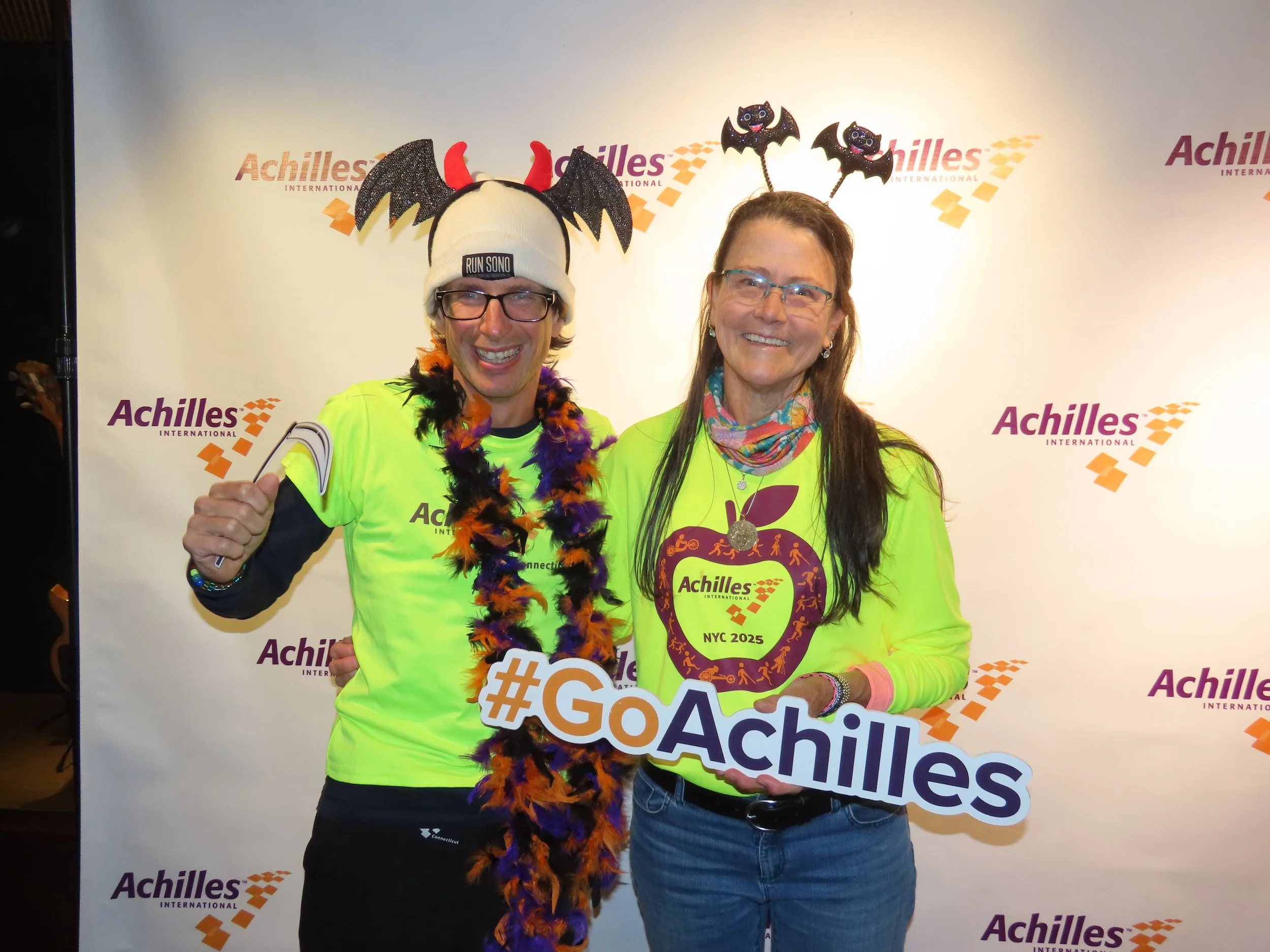  Achilles members in front of an Achilles branded step and repeat.  