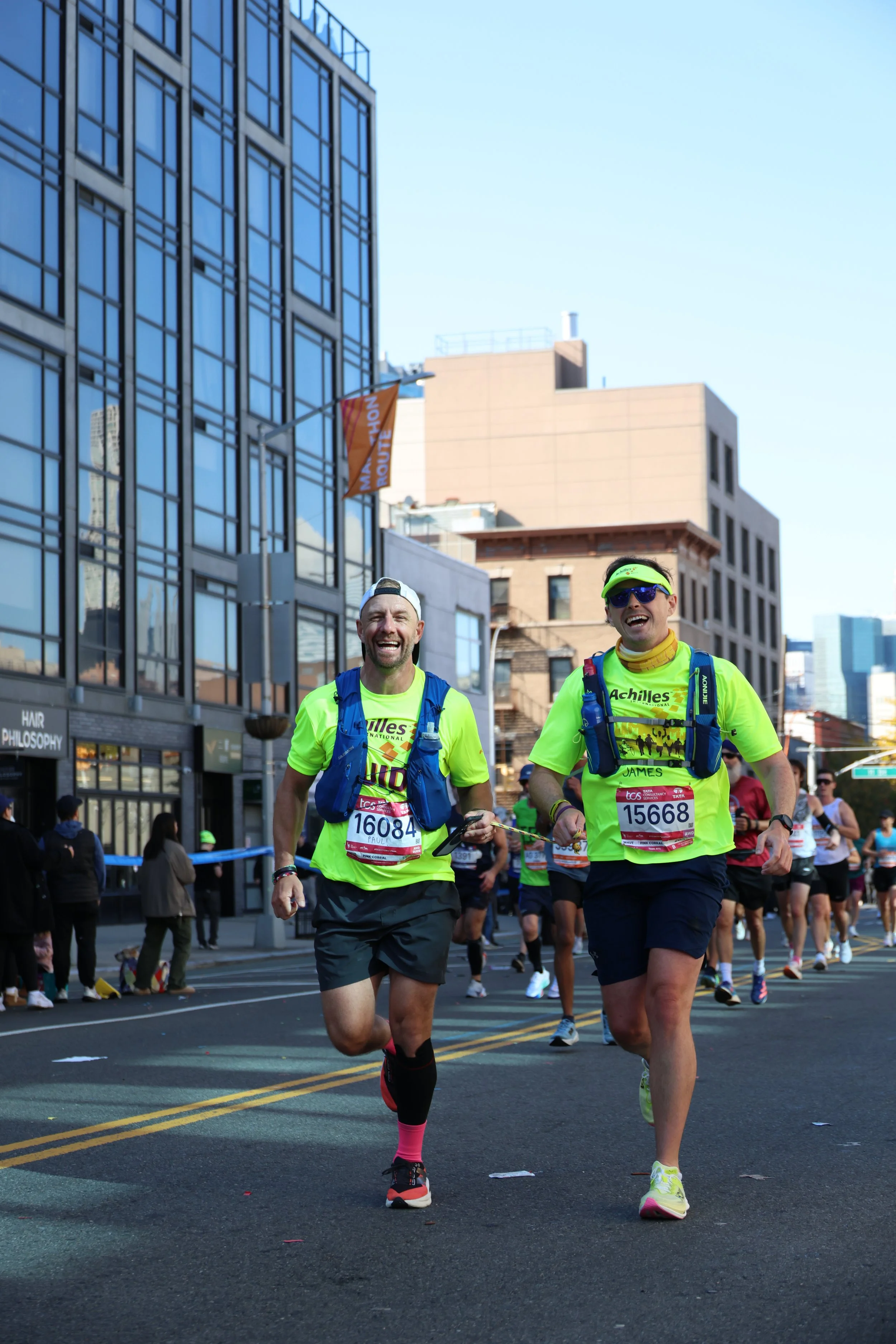  Achilles athlete smiling on the course while connected to his guide by a tether.  