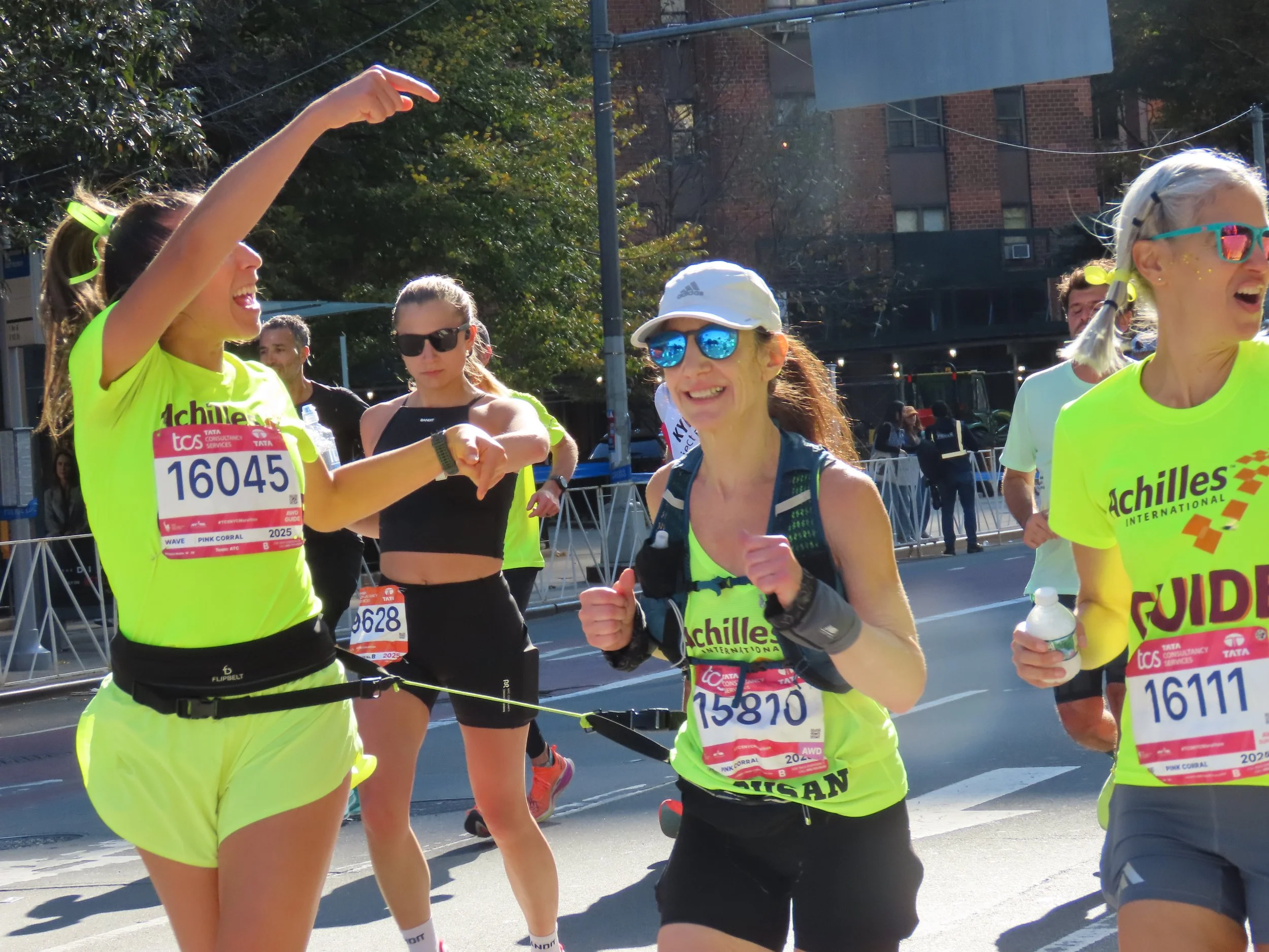  Achilles athlete smiling with her guides on the course.  
