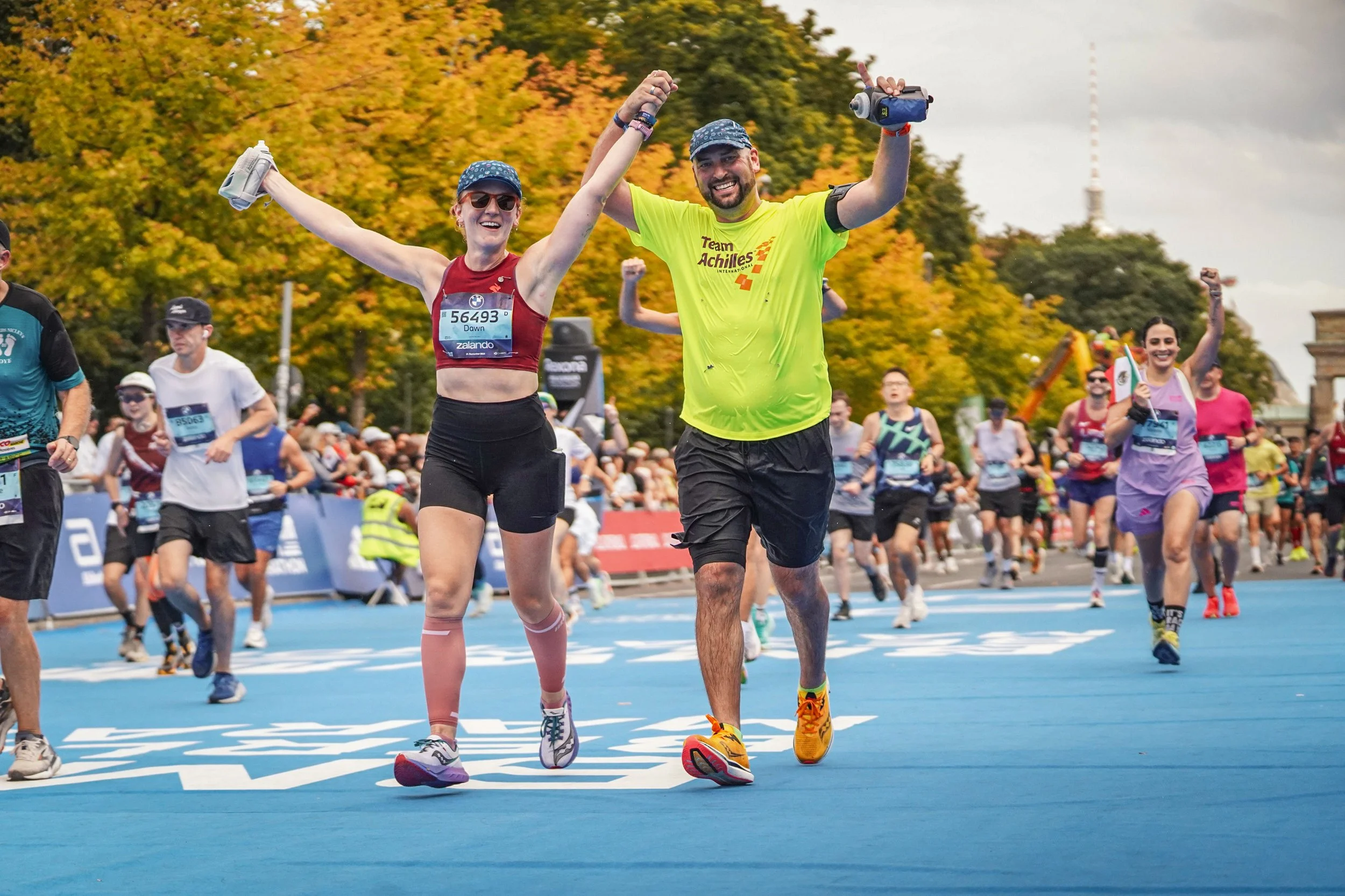  Team Achilles member cheering and smiling on the course.  