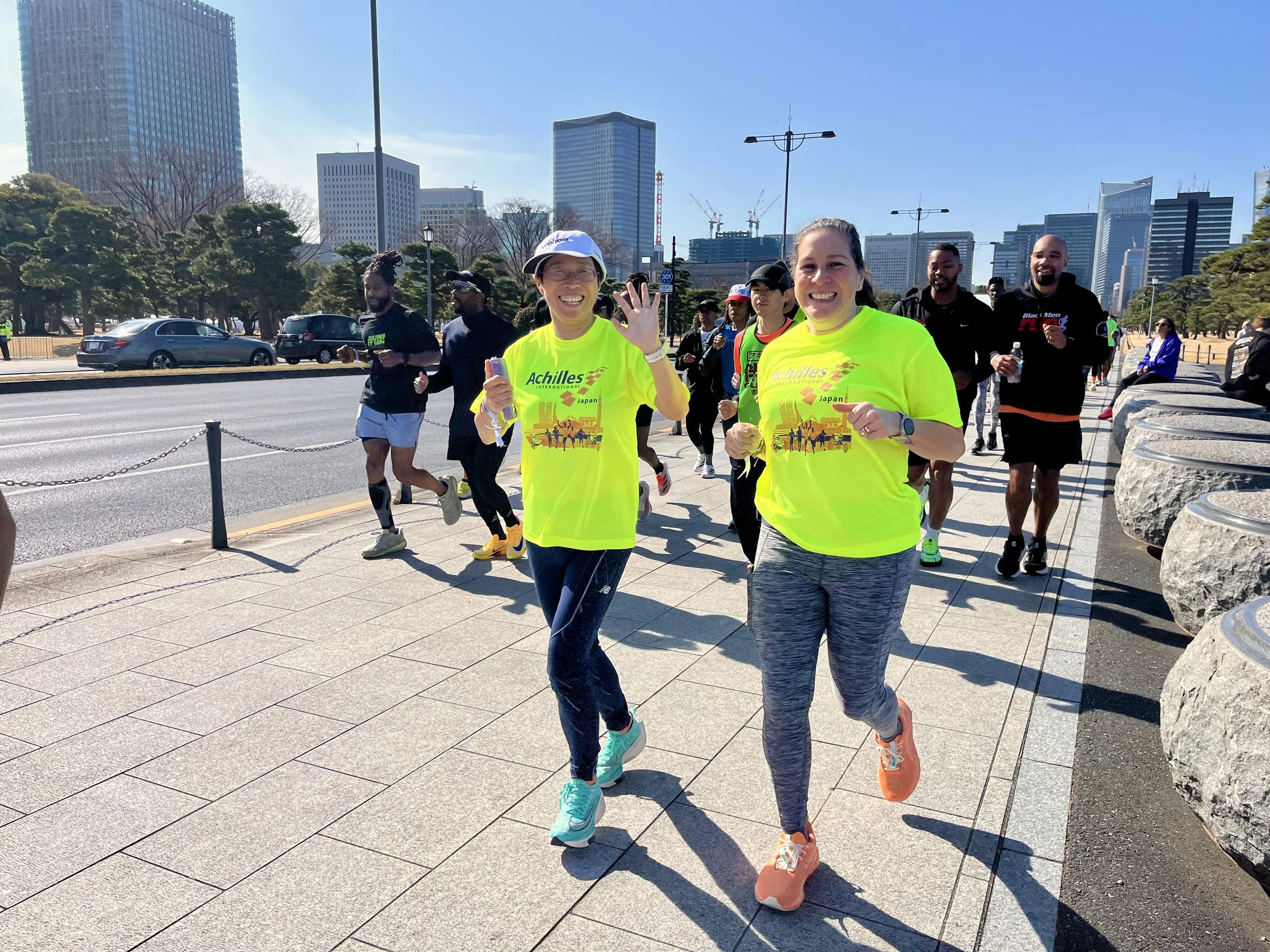  Achilles member running alongside her guide at the shakeout run.  