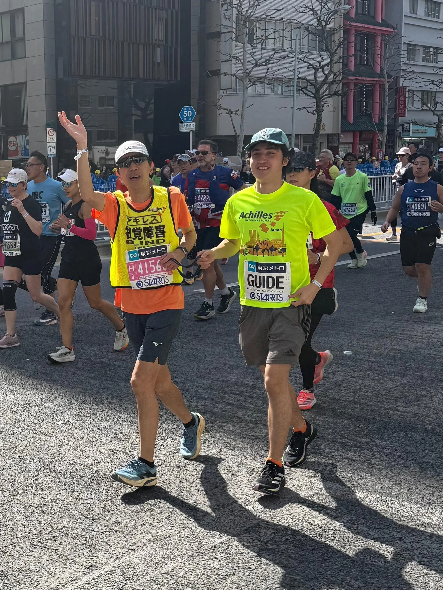  Achilles member running alongside their guide on the race course.  