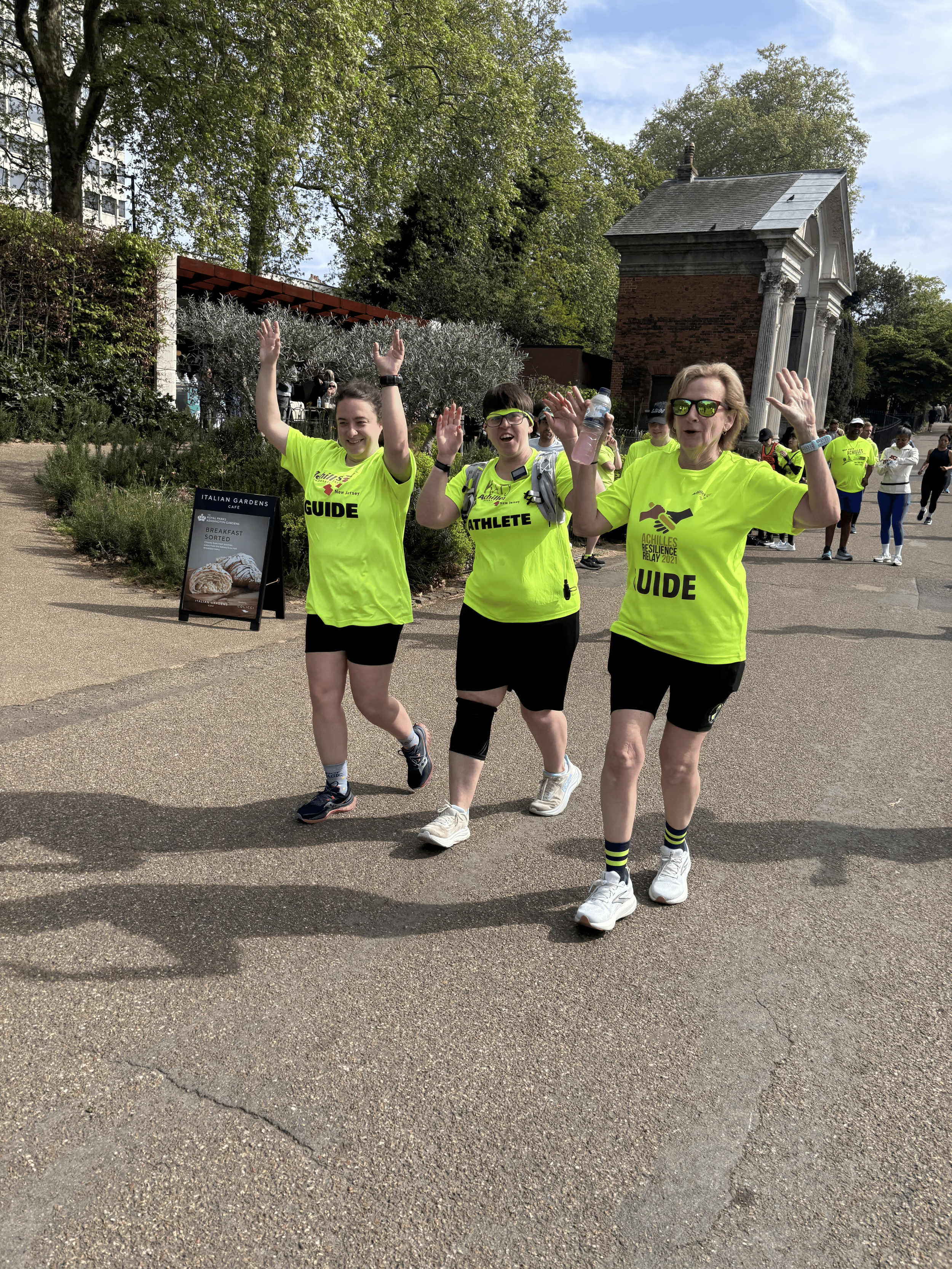  Achilles member cheering while running alongside her guides on the course.  