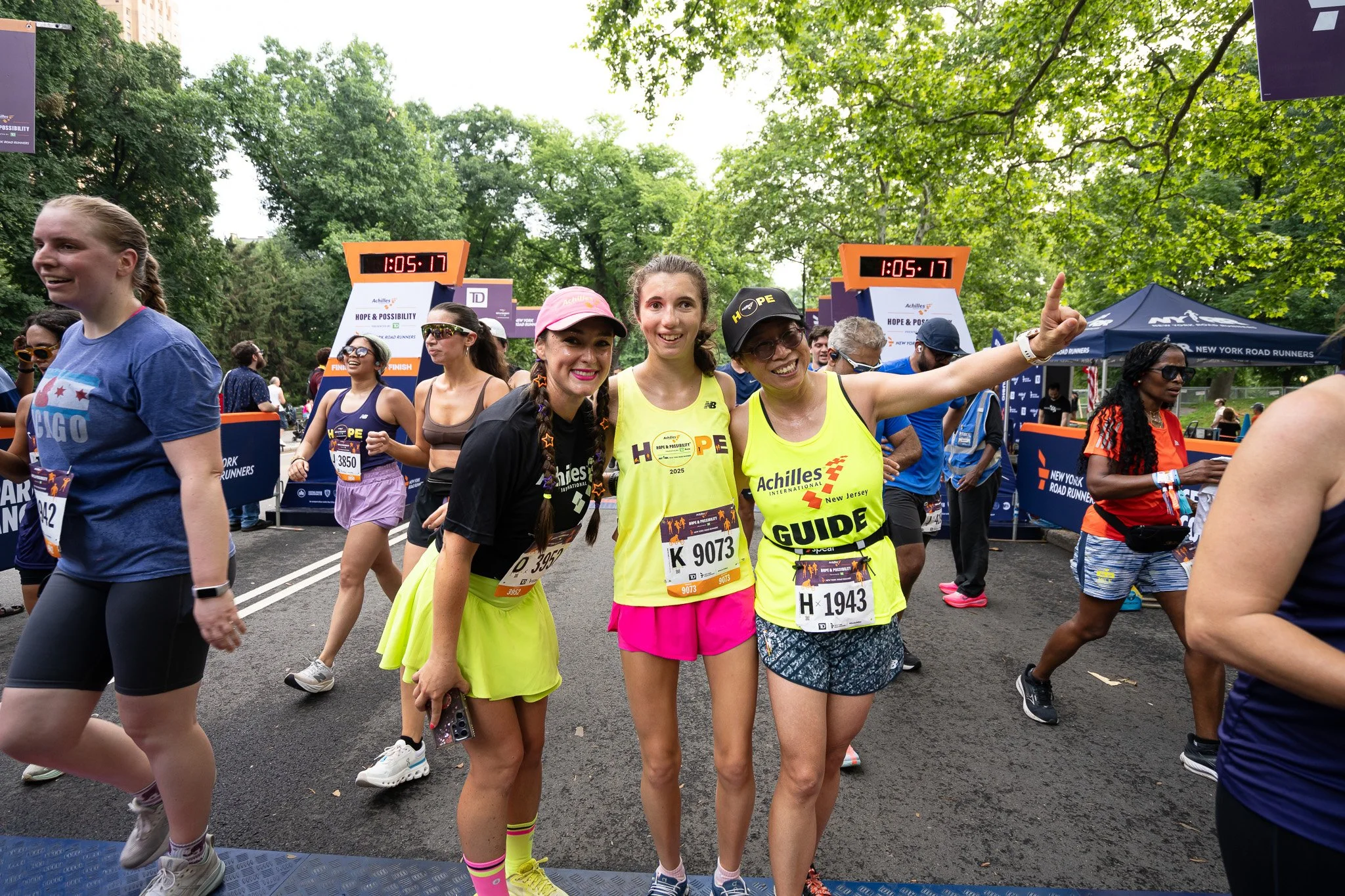  Team Achilles Kids member posing with her guides at the finish line.  