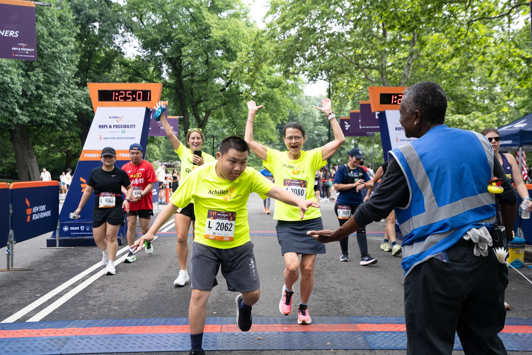  Achilles athlete crossing the finish line with his guides.  