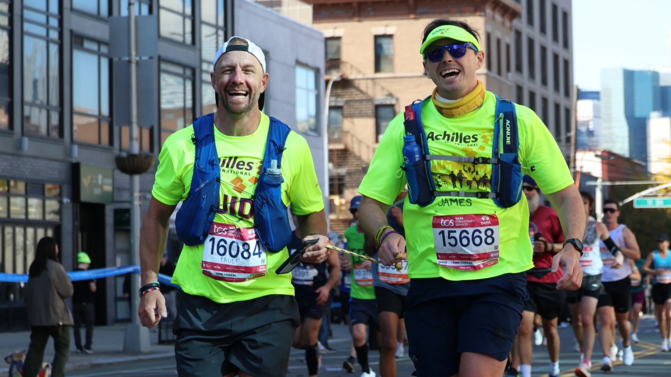 Achilles athlete in a wheelchair with his two guides on both sides of him during the New York City Marathon