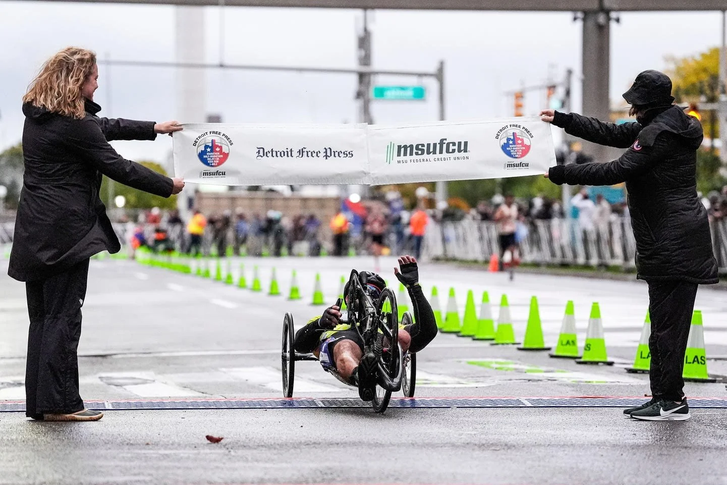 Achilles Freedom Team athlete crossing the Detroit Marathon finish line on his handcycle.