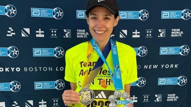 Team Achilles runner Antonio smiling with arms outstretched and Chicago Marathon race bib