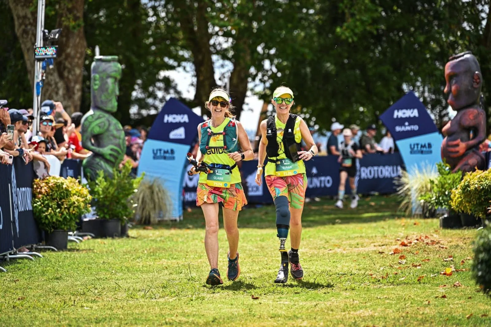 Guide crossing finish line with Achilles athlete