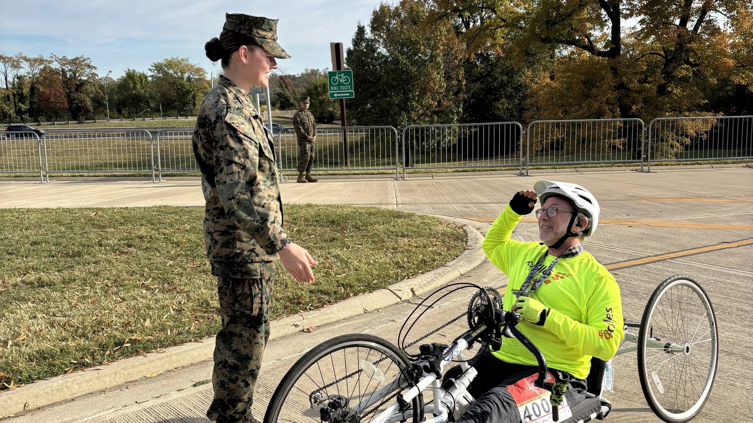 Achilles Freedom Team member posing under a branded arch at the Marine Corps Marathon