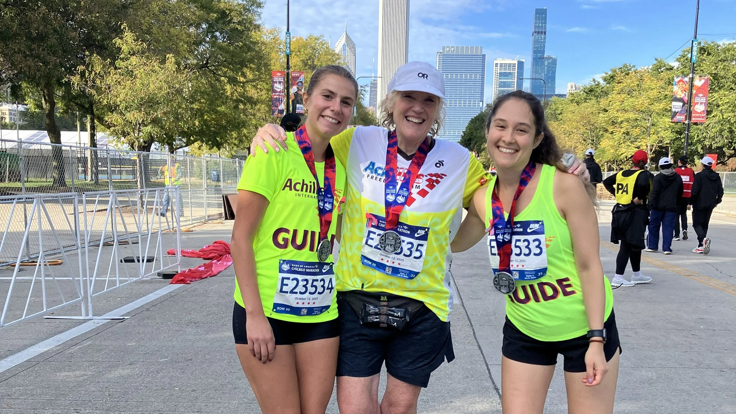 Achilles athlete smiling with his guide who is giving a thumbs up at the Chicago Marathon