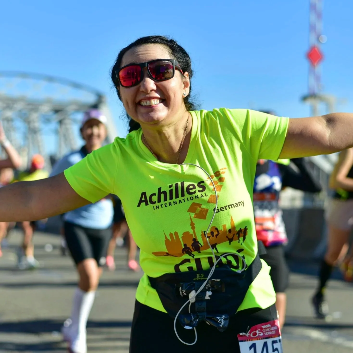 Achilles Guide smiling and cheering on a race course.