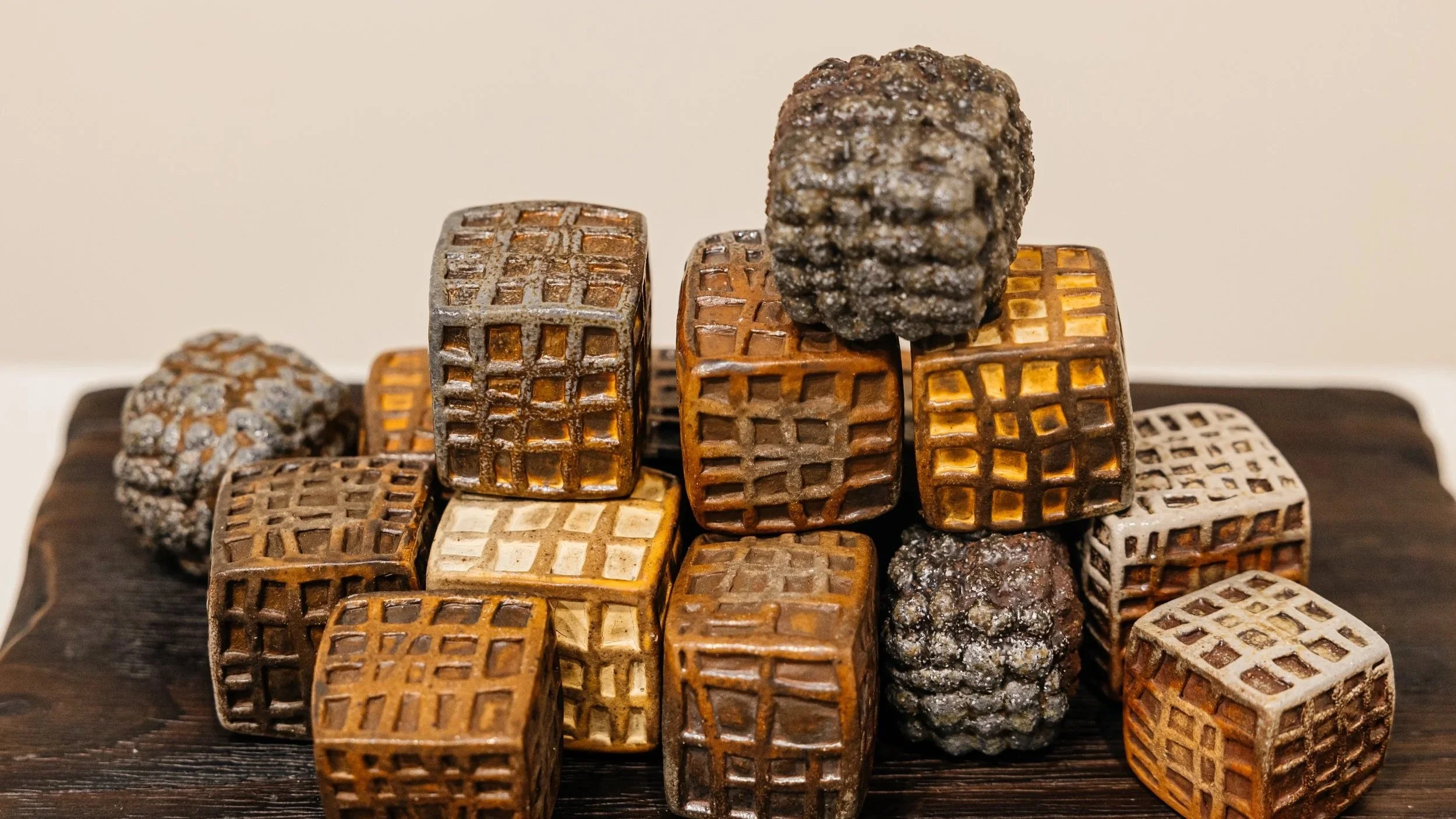 "Containment"
Textured wood soda fired ceramic cubes arranged on a charred wood base