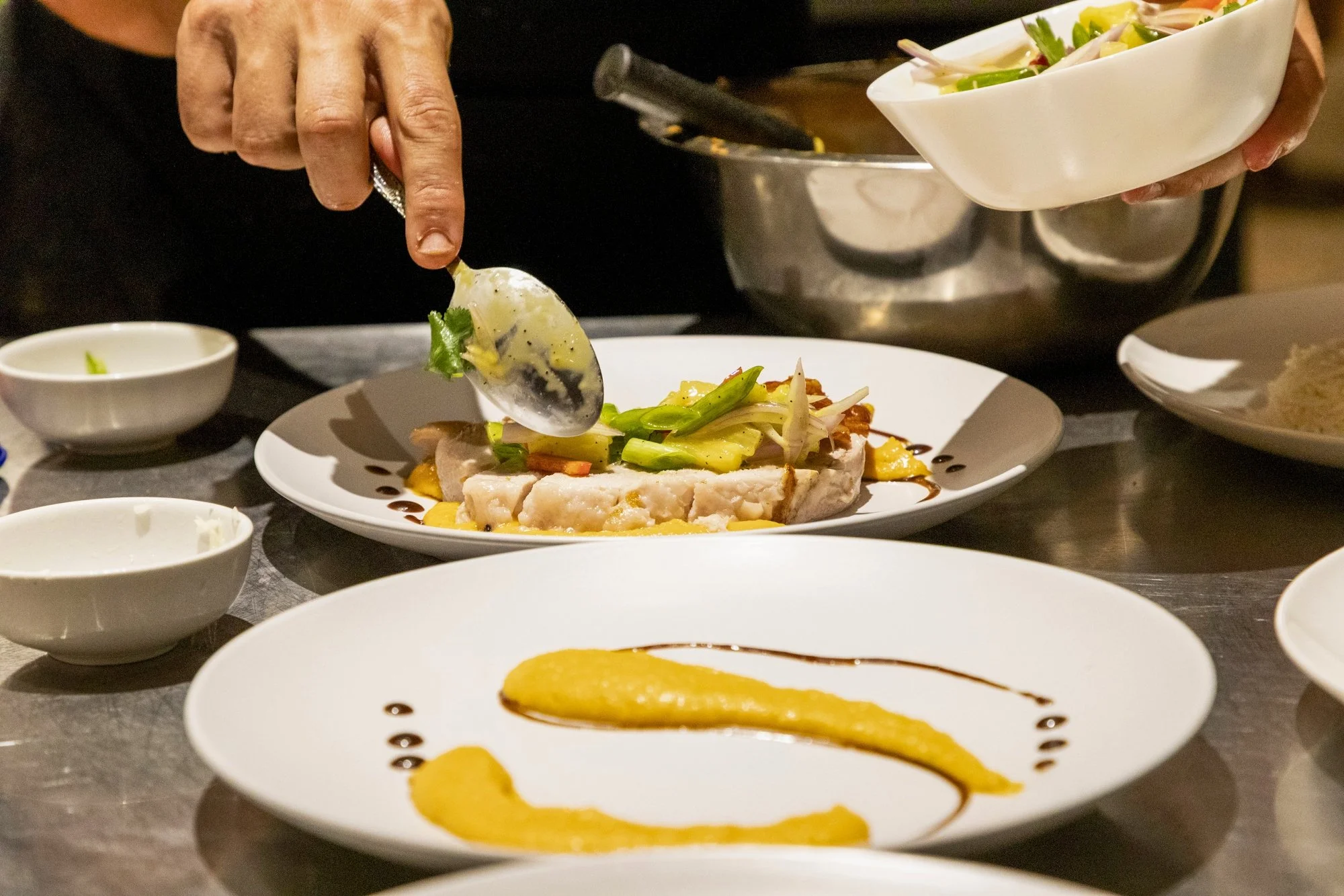 Chef plating pork with pineapple salsa