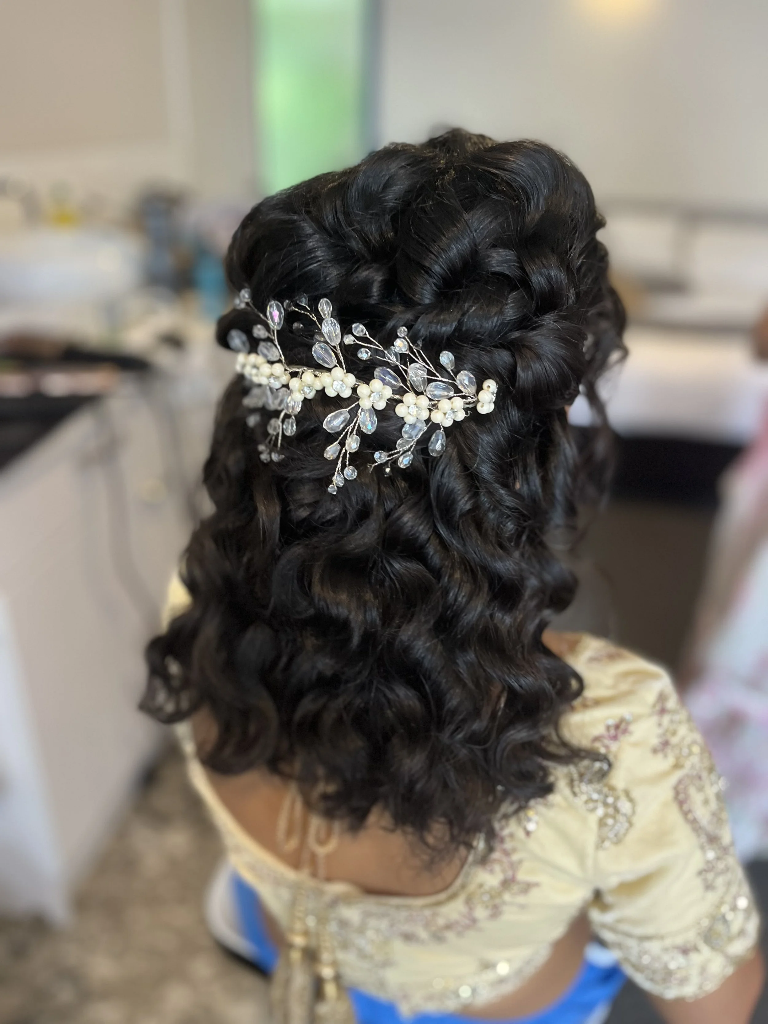brides natural curls enhanced for her wedding day into a half up bridal hairstyle and accented with a floral hairclip