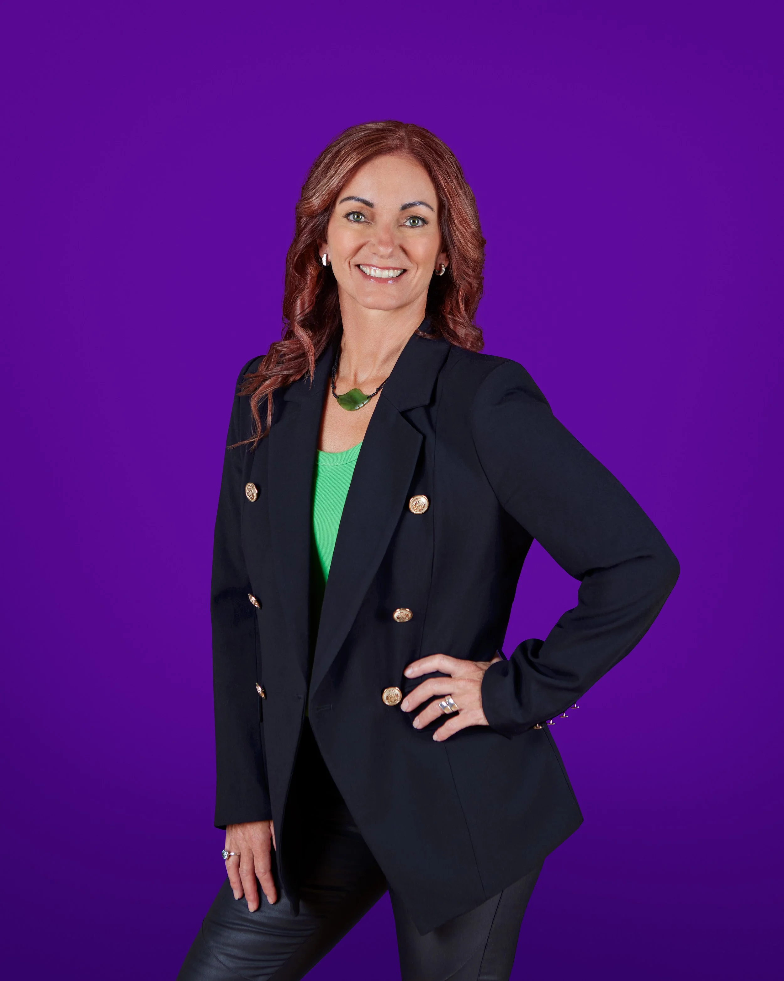 business woman posing for a professional photoshoot and headshot for her website, she has minimal makeup to compliment her face and naturally styled hair