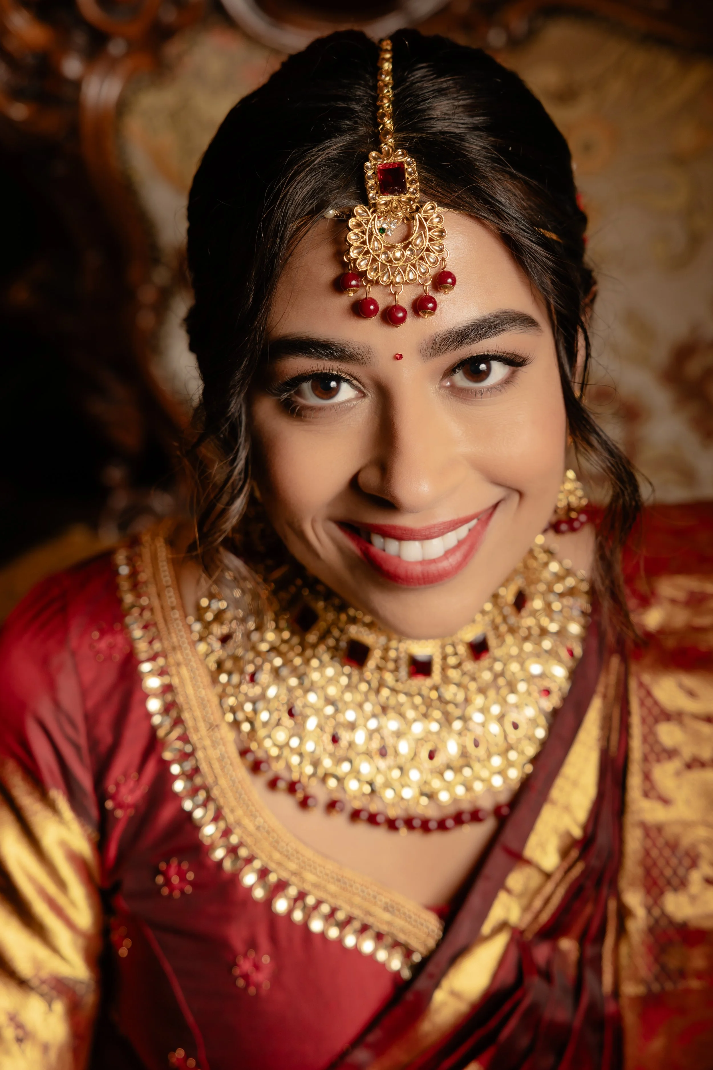 Punjabi bride in red saree with soft bridal makeup look and bridal hairdo for her wedding day in Auckland NZ