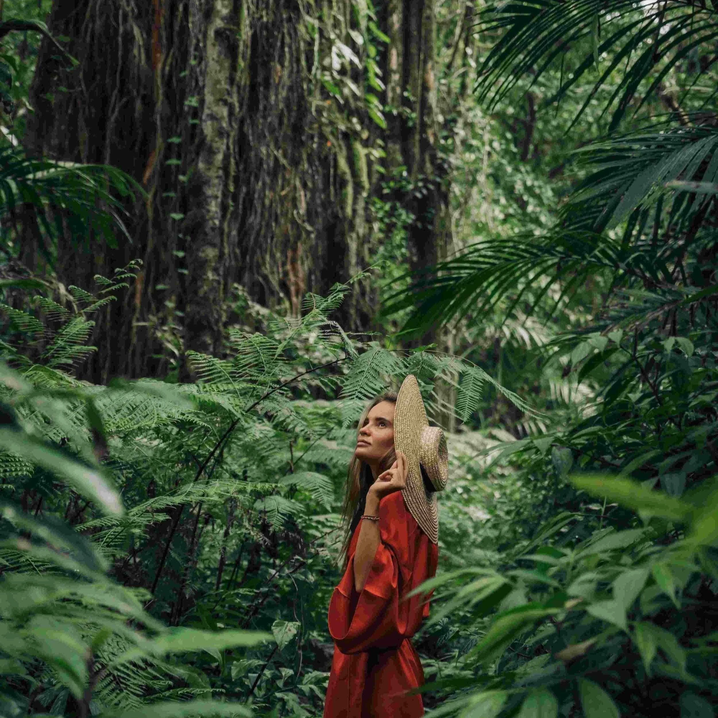 Woman standing inside an ancient forest
