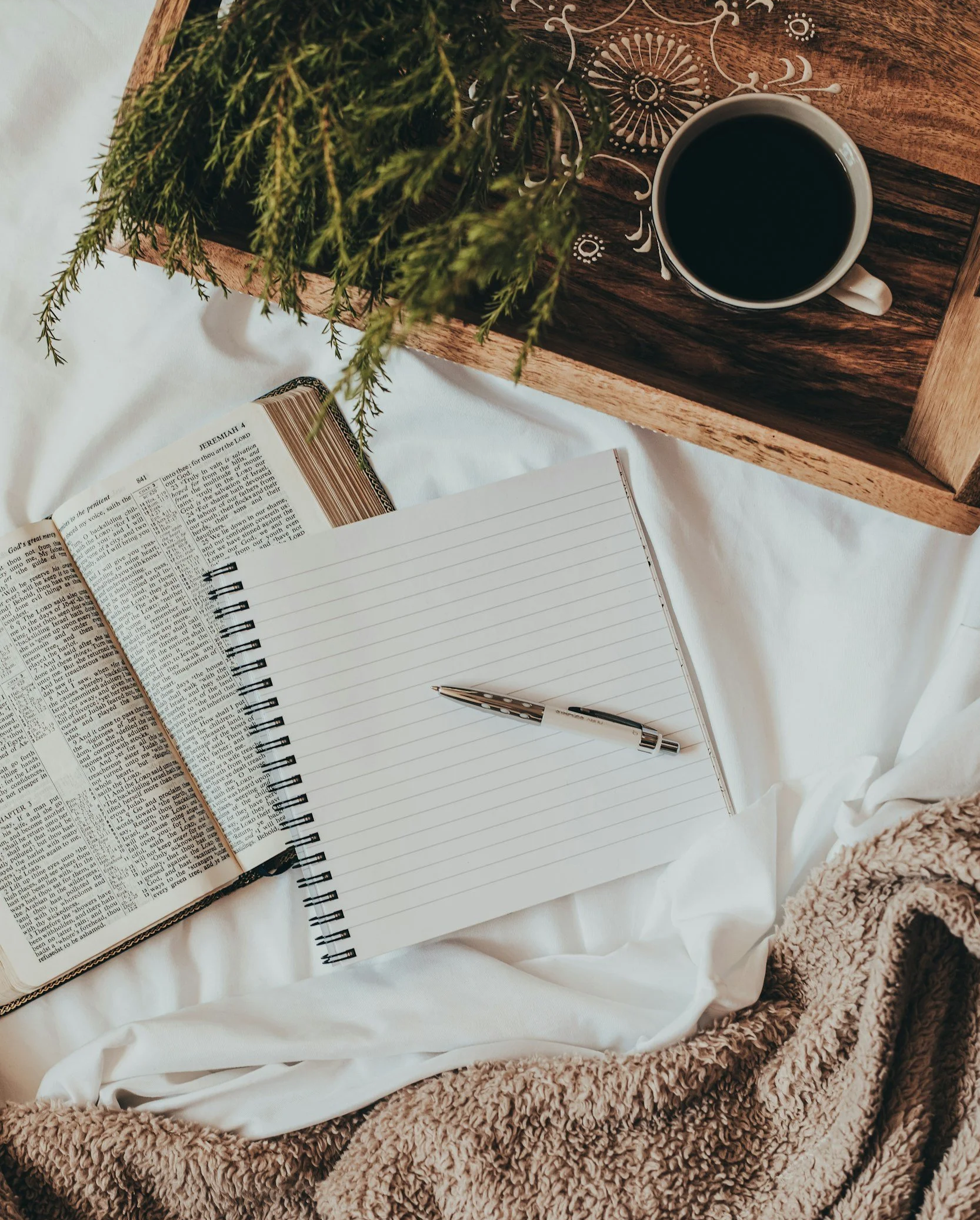 Open journal and pen resting on a bed