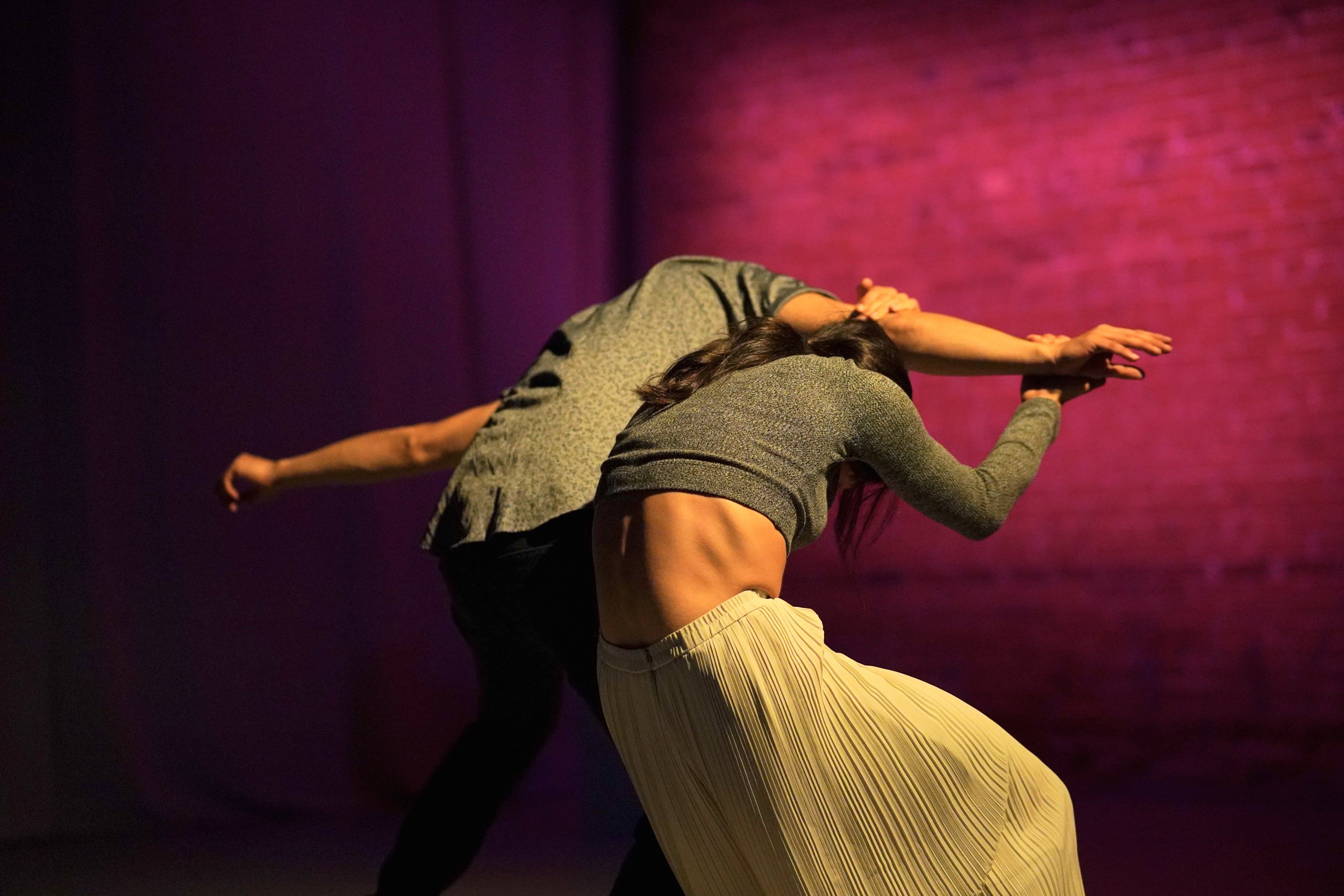 Both dancers are hunched over facing away from the camera.