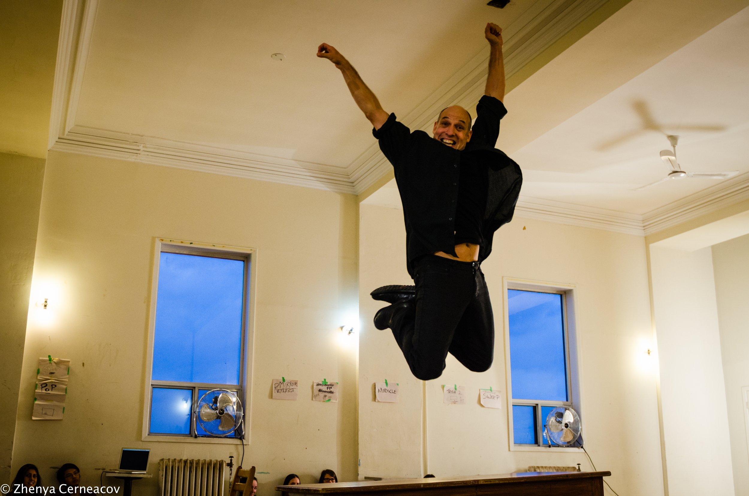 Allen leaps into the air with arms raised overhead.