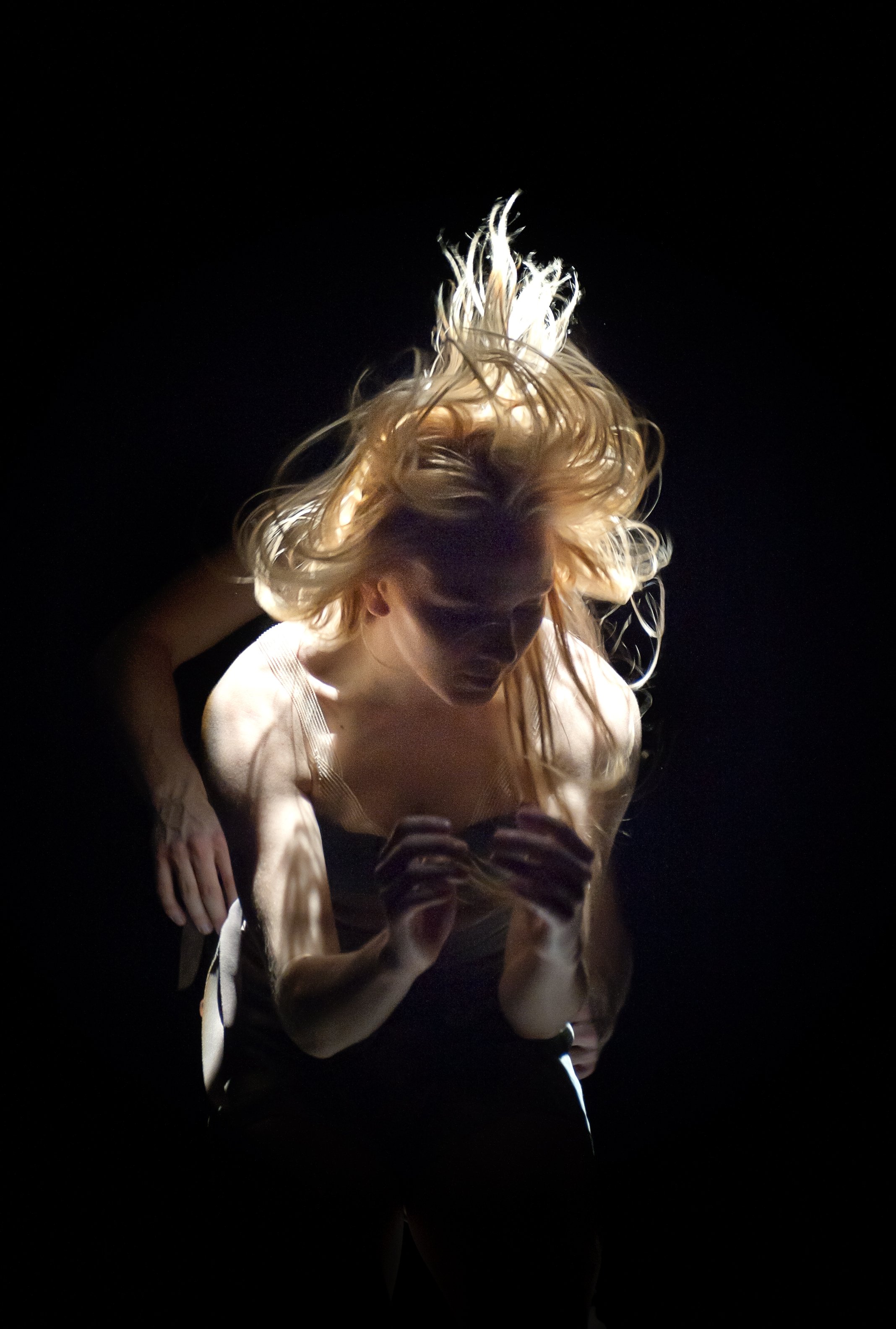 A close up of a dancer with their hair flying around their face.
