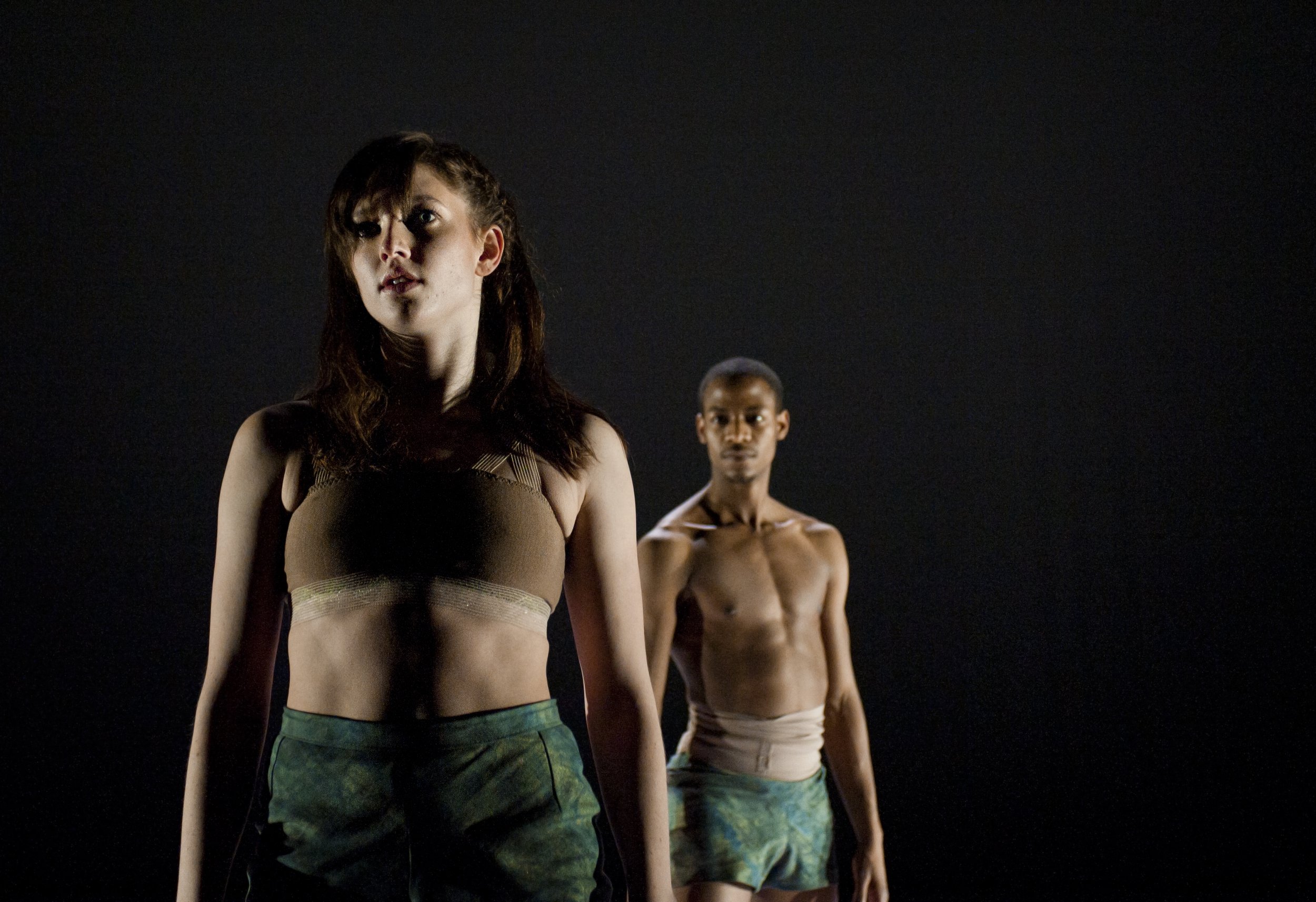 Two dancers stand facing forwards.