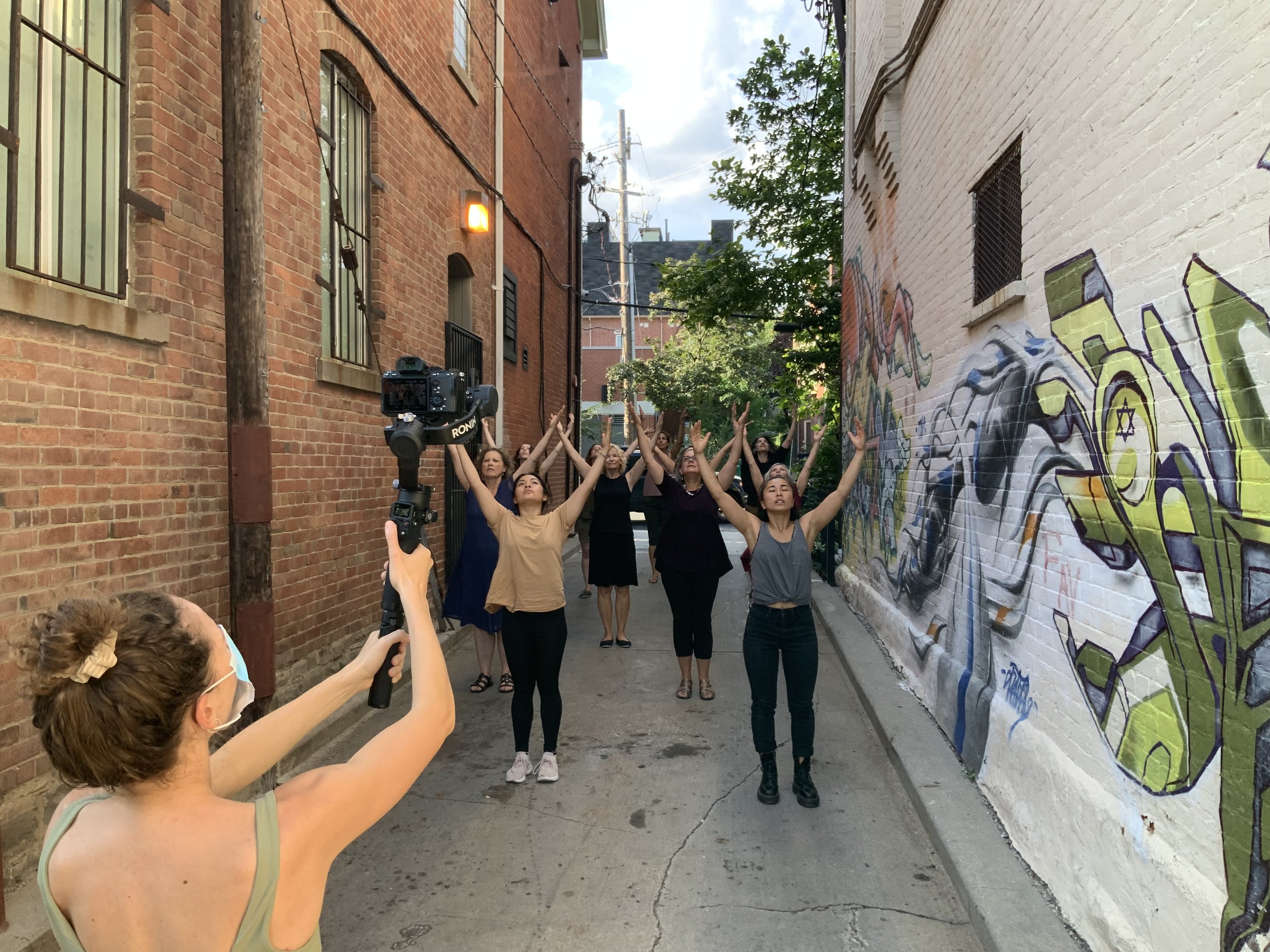 Community participants with arms raised overhead