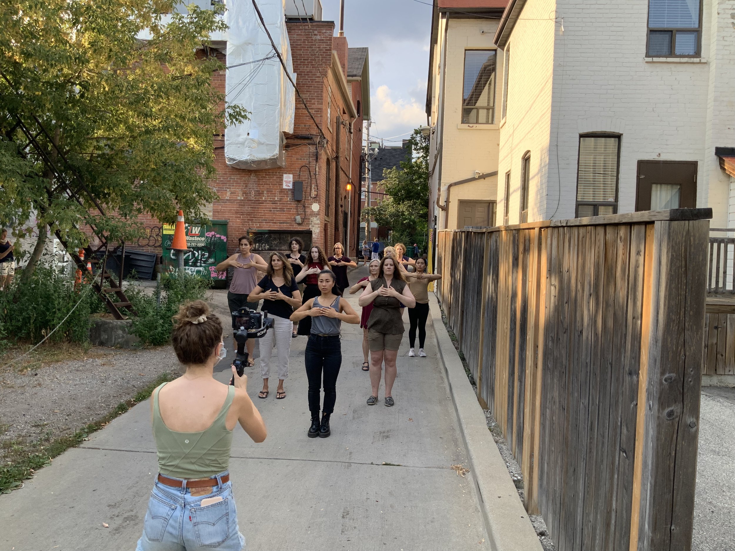 A group of participants stand with hands over their hearts